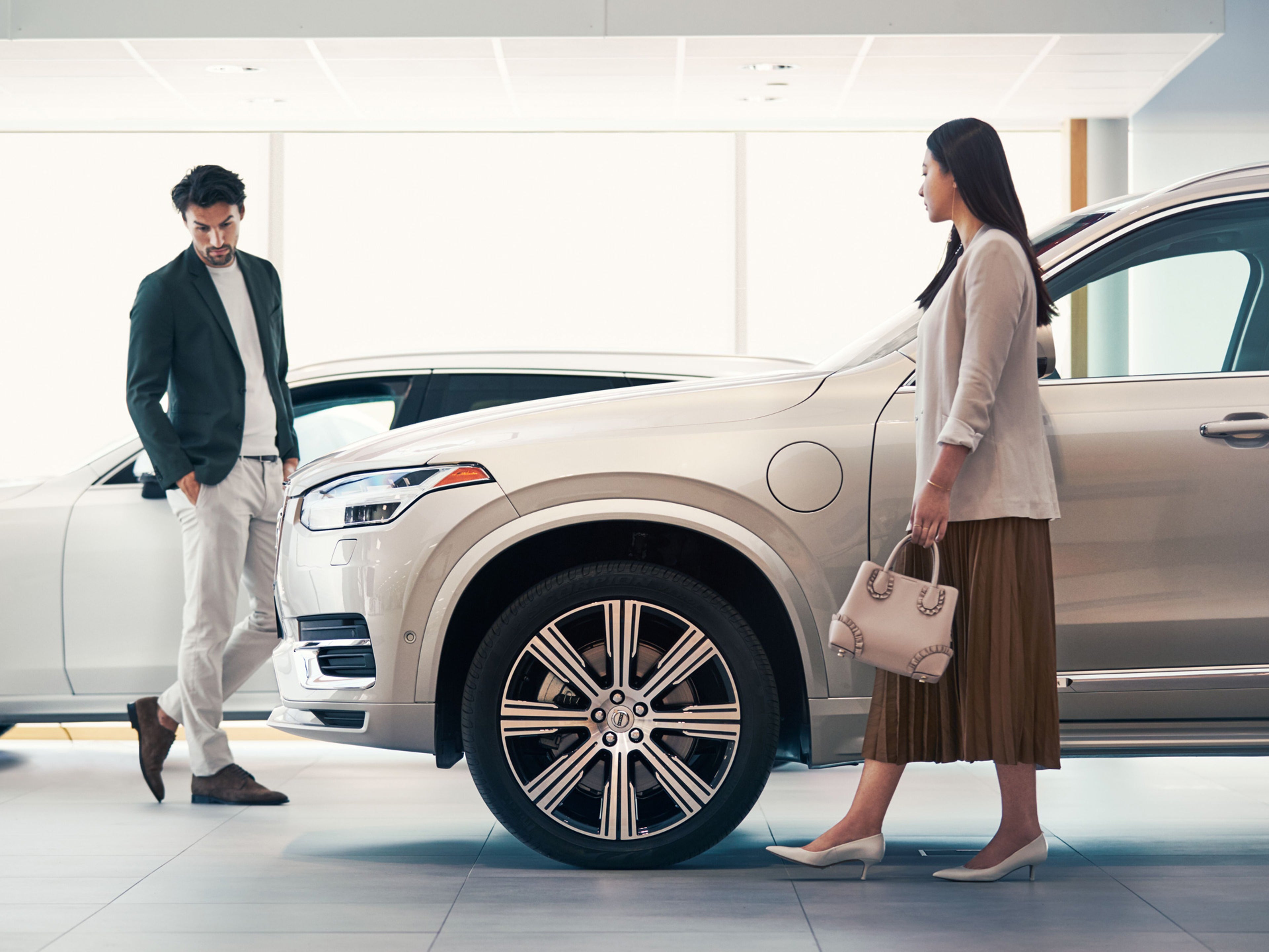Una mujer y hombre observando un Volvo XC90