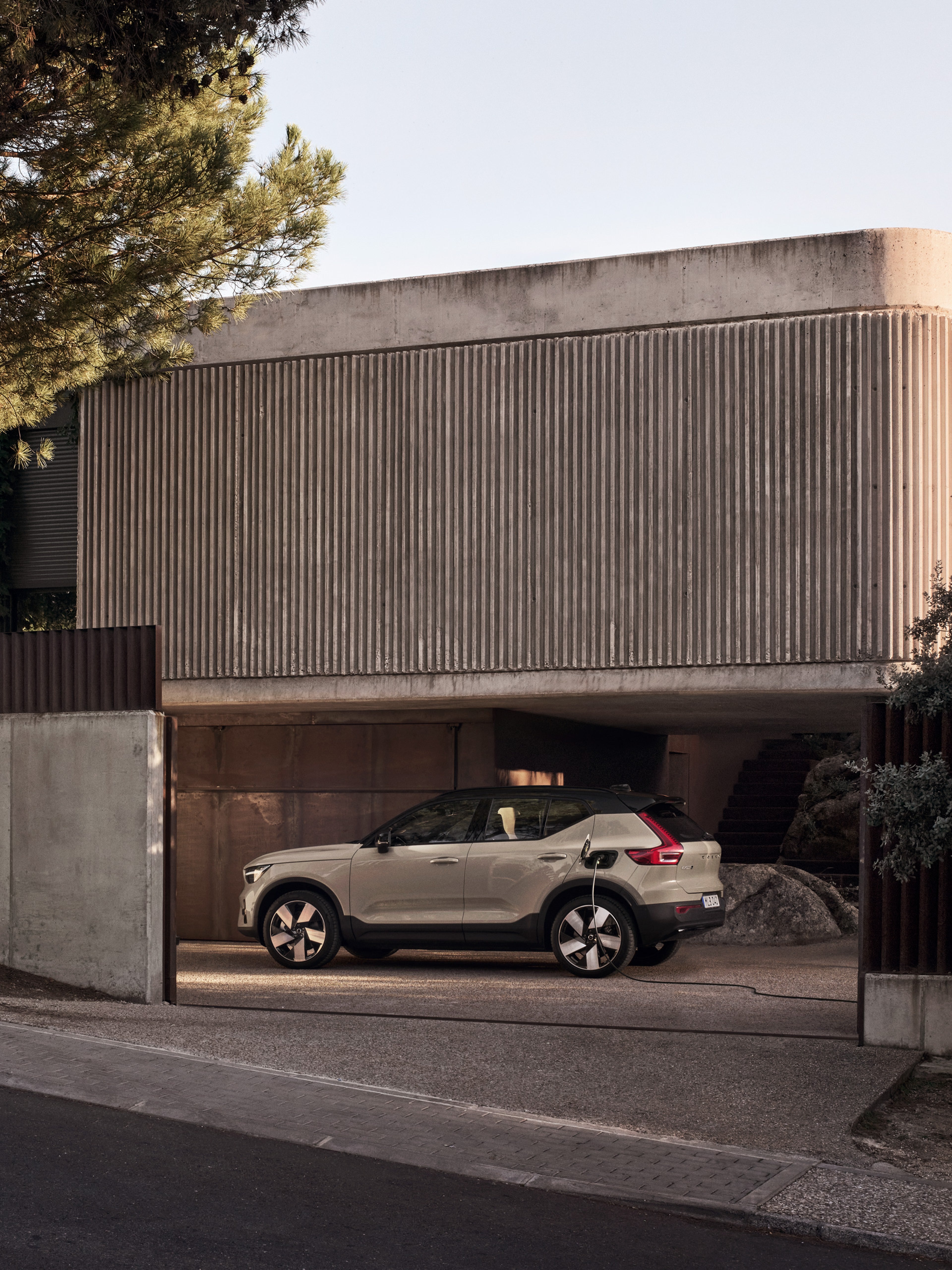 Volvo EX40 na entrada da garagem de um edifício residencial moderno