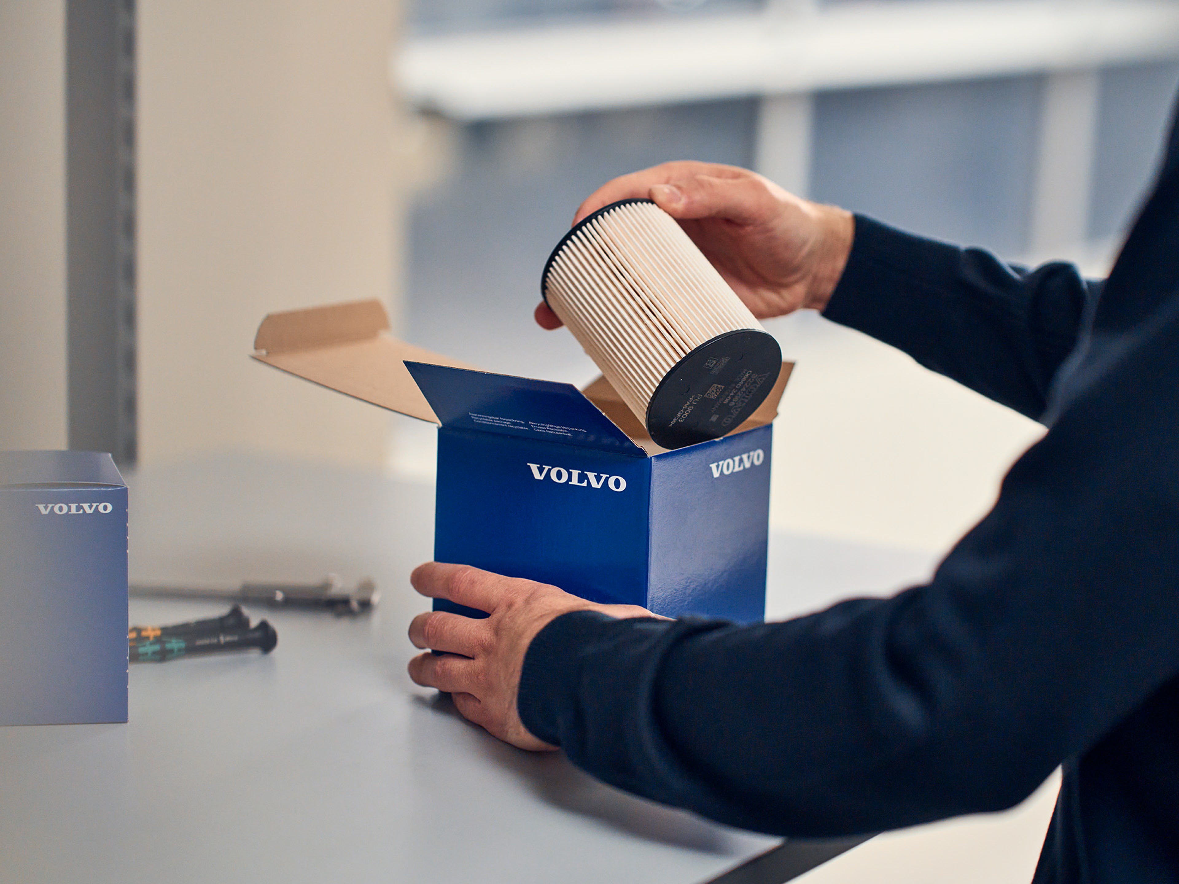 Homem a agarrar um filtro de particulas genuino volvo