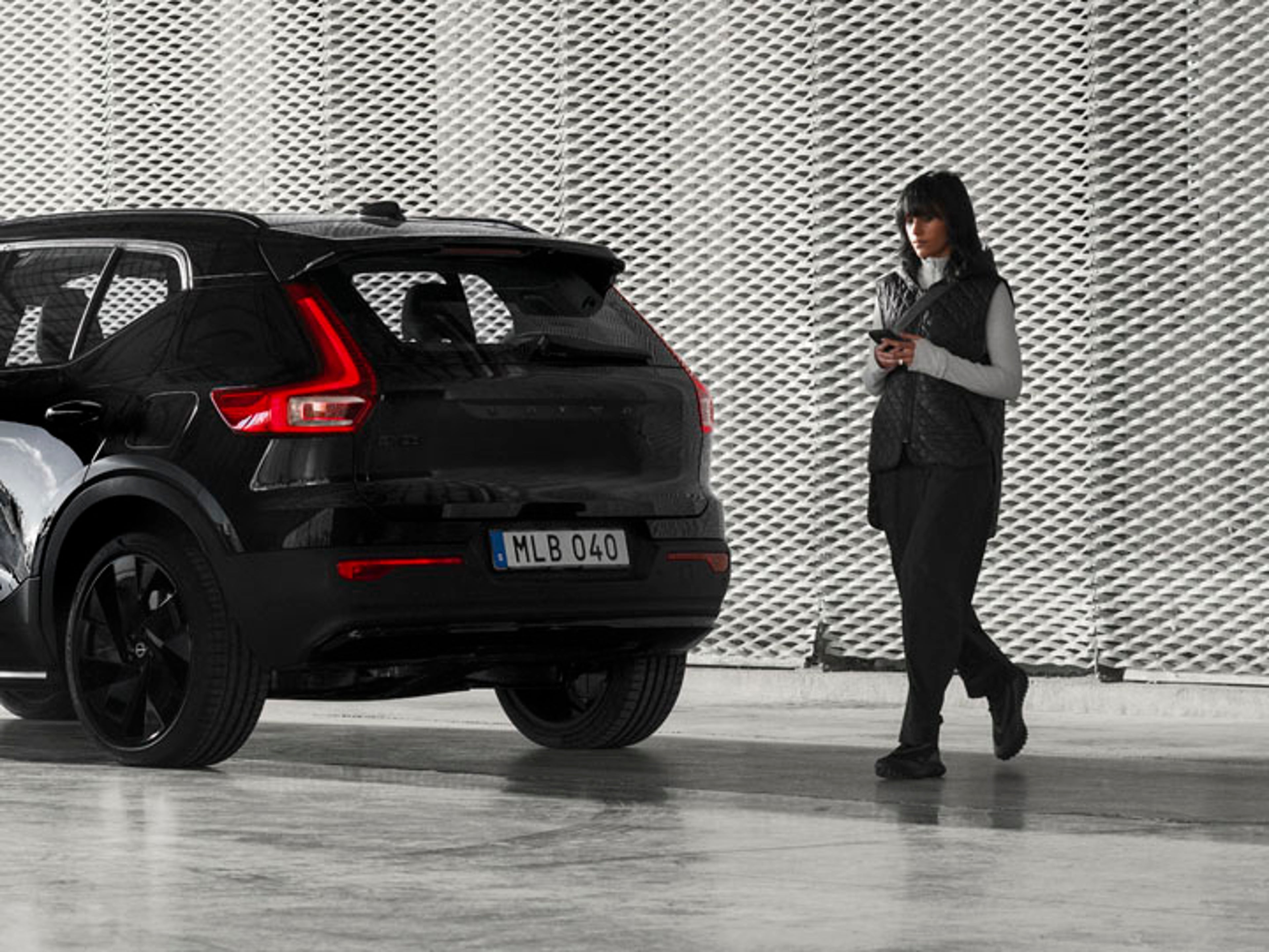 Volvo EX40 con una mujer al lado