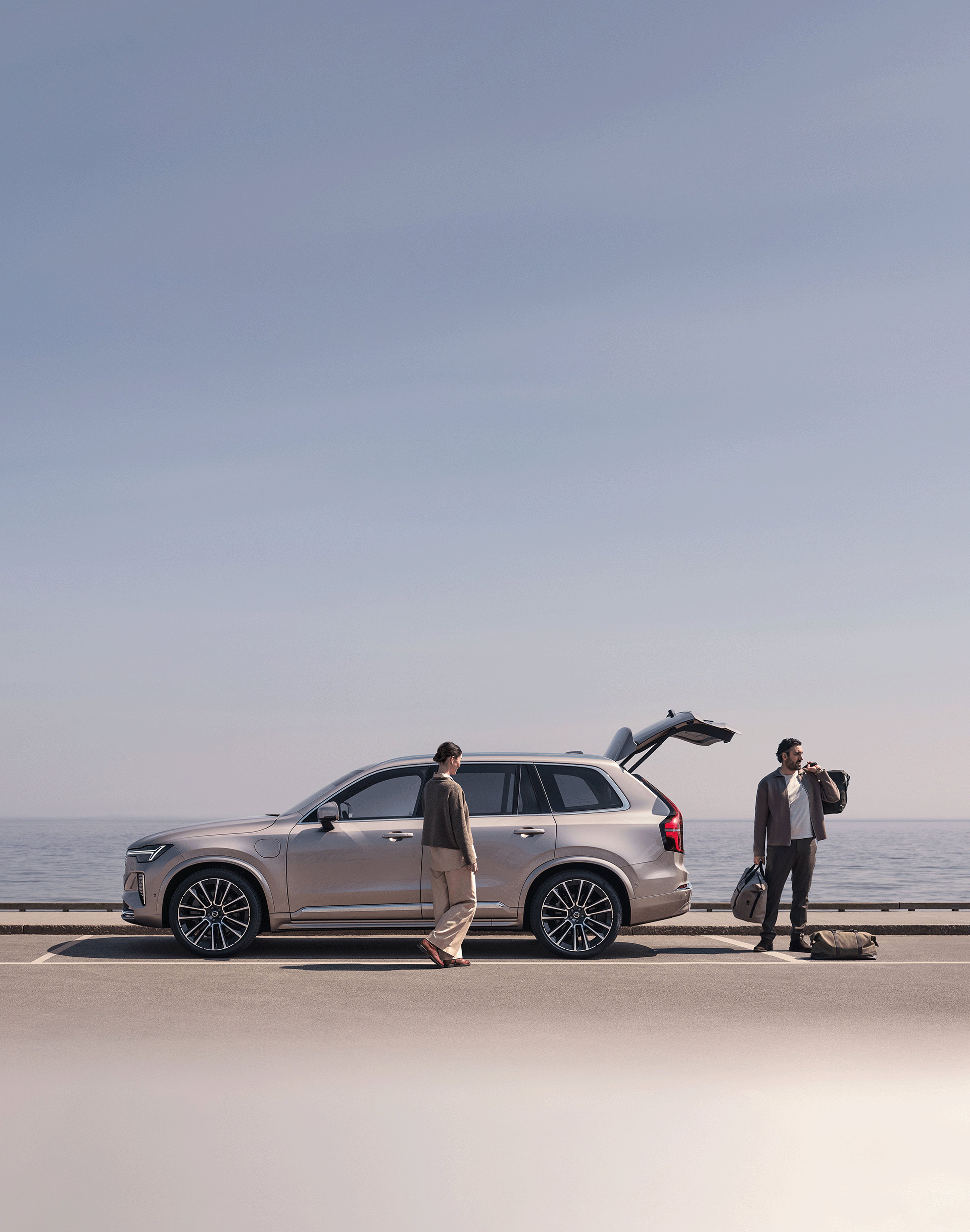 Zwei Personen beladen einen Volvo XC90.