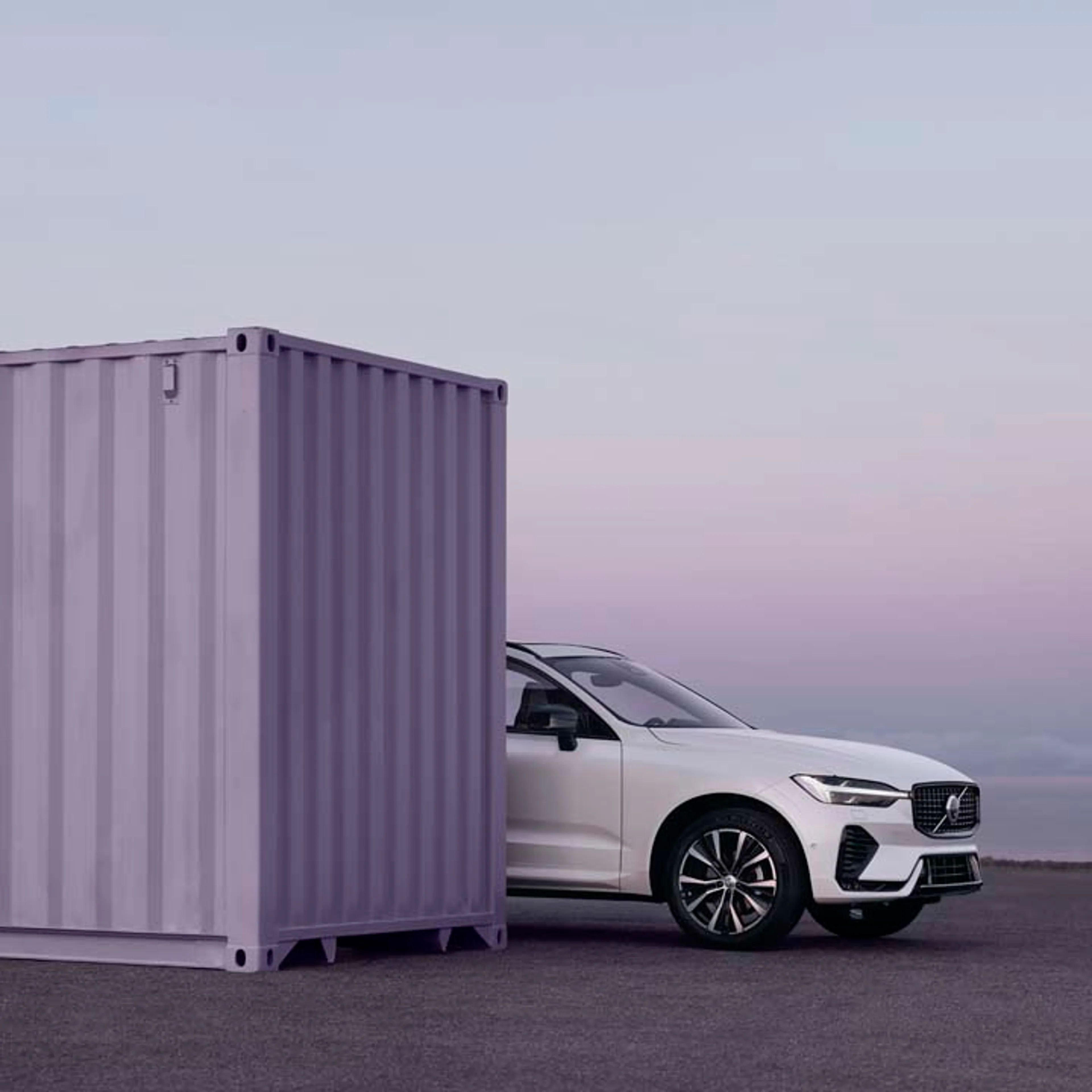 Volvo XC60 mild hybrid sobresaliendo detrás de un contenedor morado