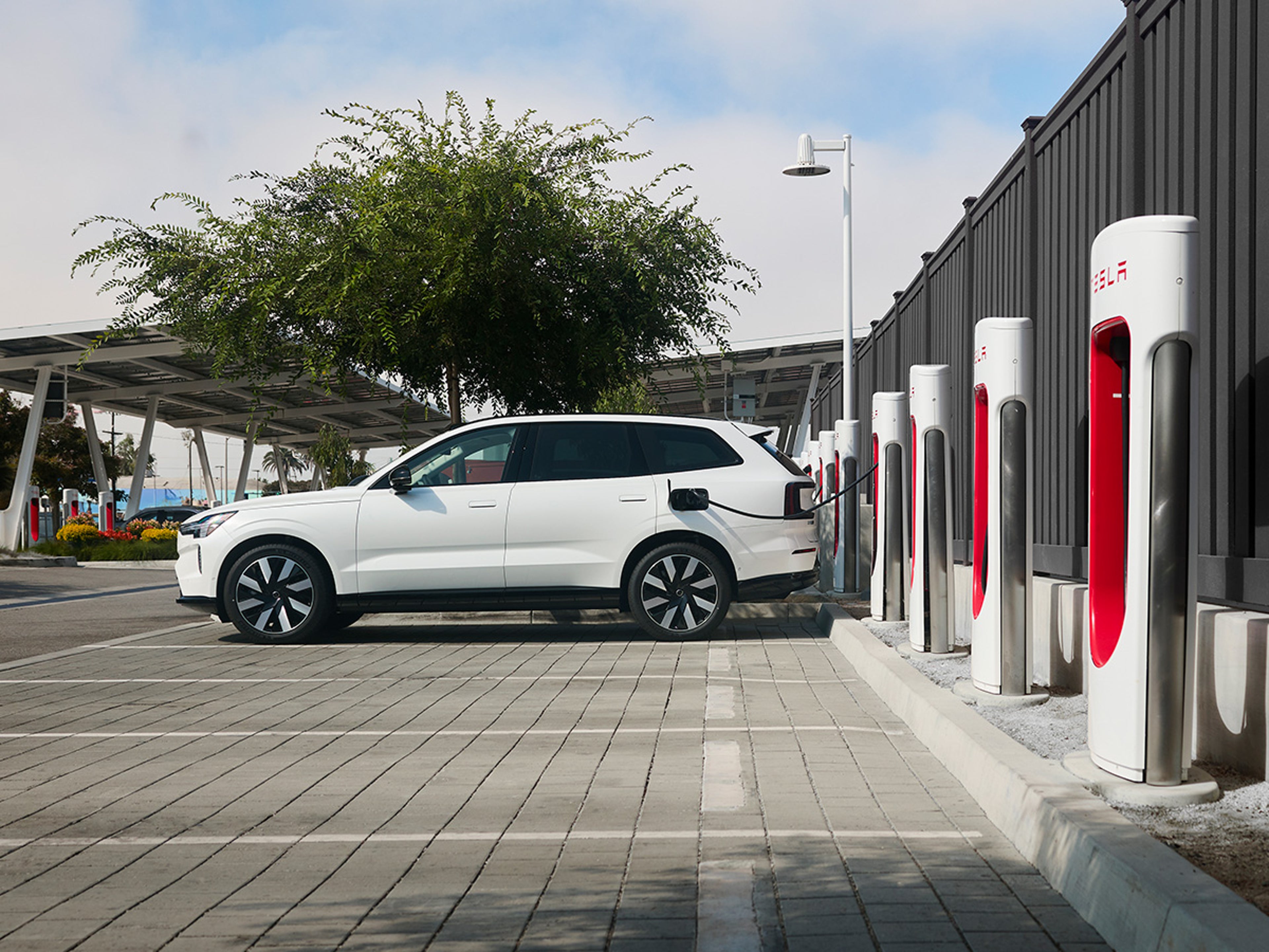 EX90 charging at a Tesla Supercharger