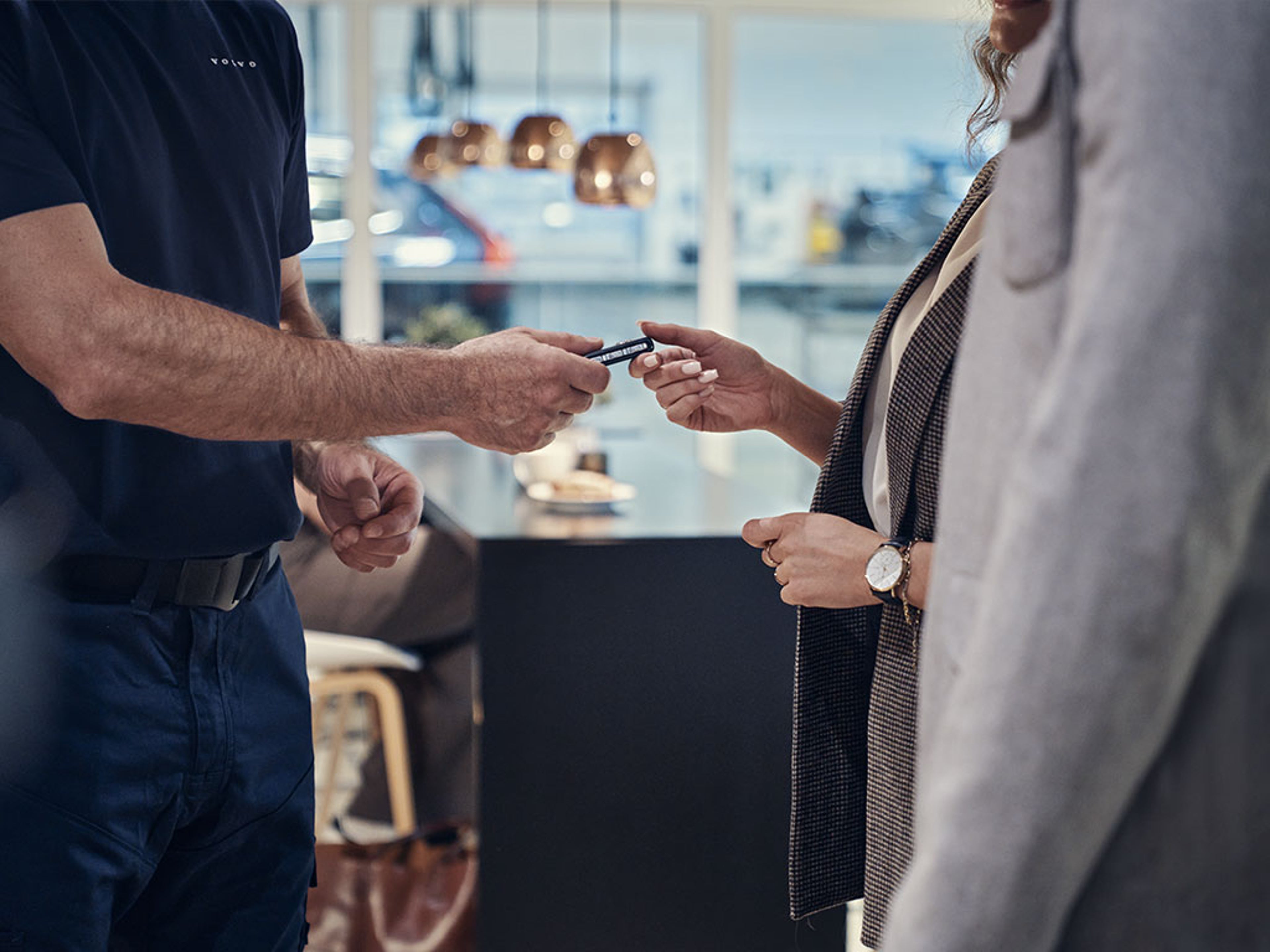 Deux personnes s’échangent une clé de voiture dans un bureau