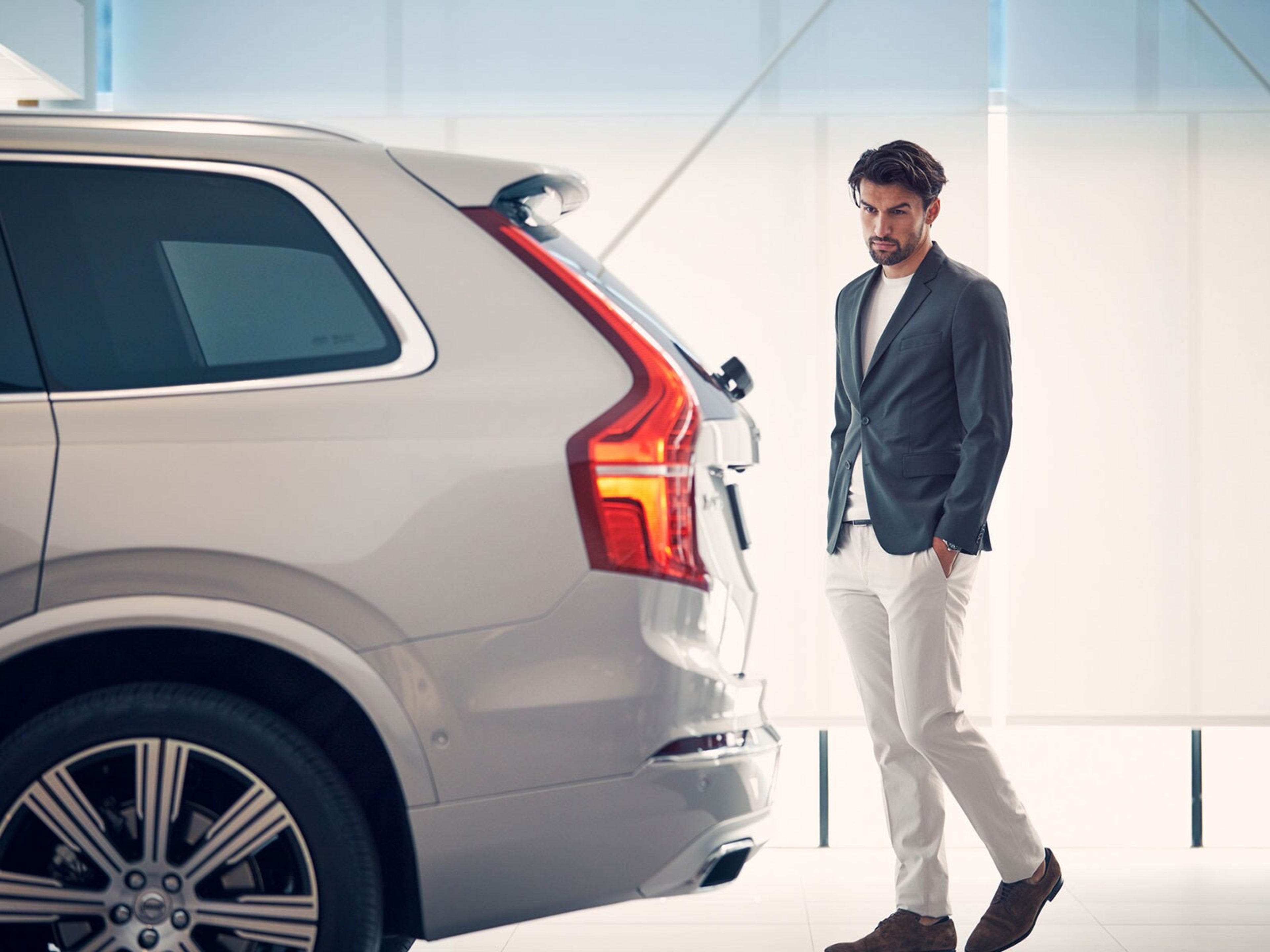 Вид сбоку на Вольво XC90 и клиента в салоне