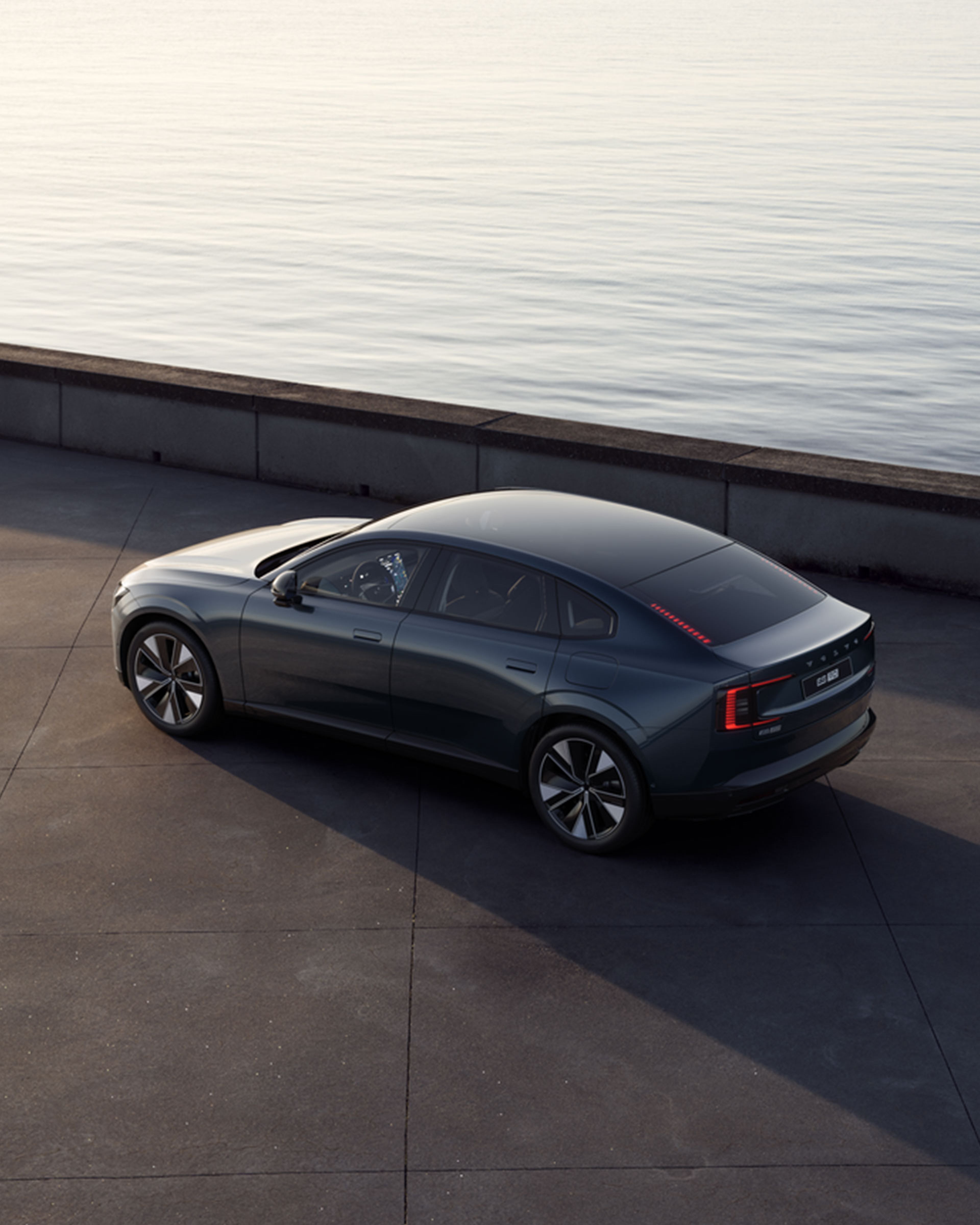 ES90 grise vue de ¾ arrière sur un stationnement au bord de l’eau