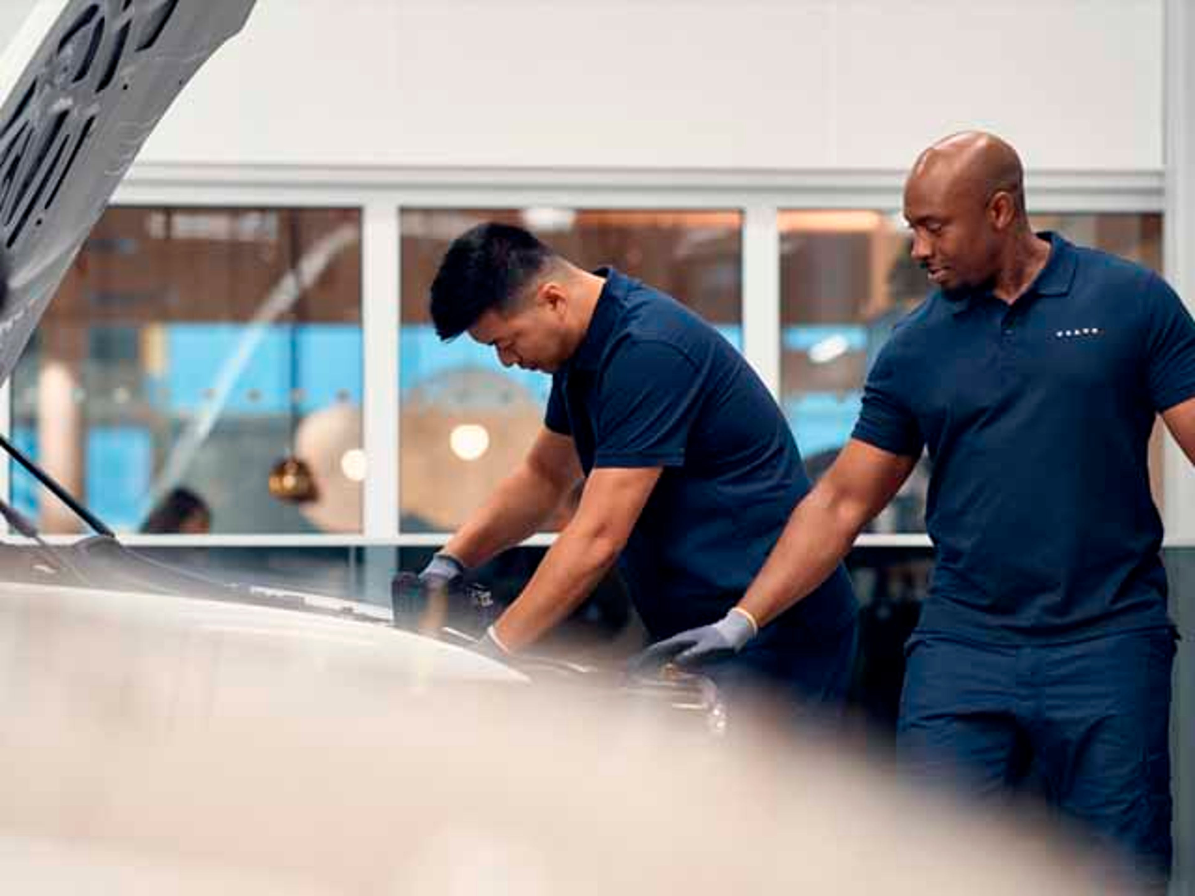 Dos mecánicos de una instalación Volvo comprobando un vehículo