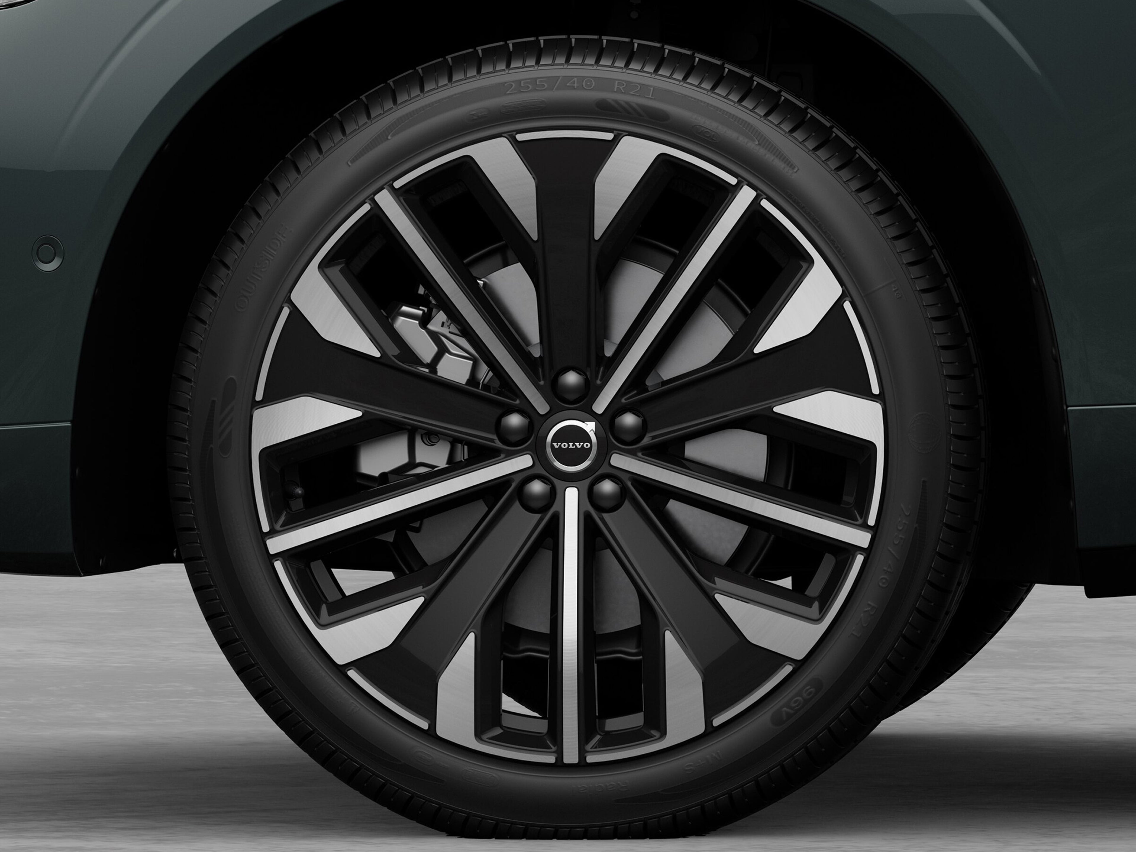 Lähikuva Forest lake -värisen Volvo XC60 lataushybridikatumaasturin renkaasta, jossa on 21 tuumainen 5-V spoke glossy black diamond cut alumiinivanne.