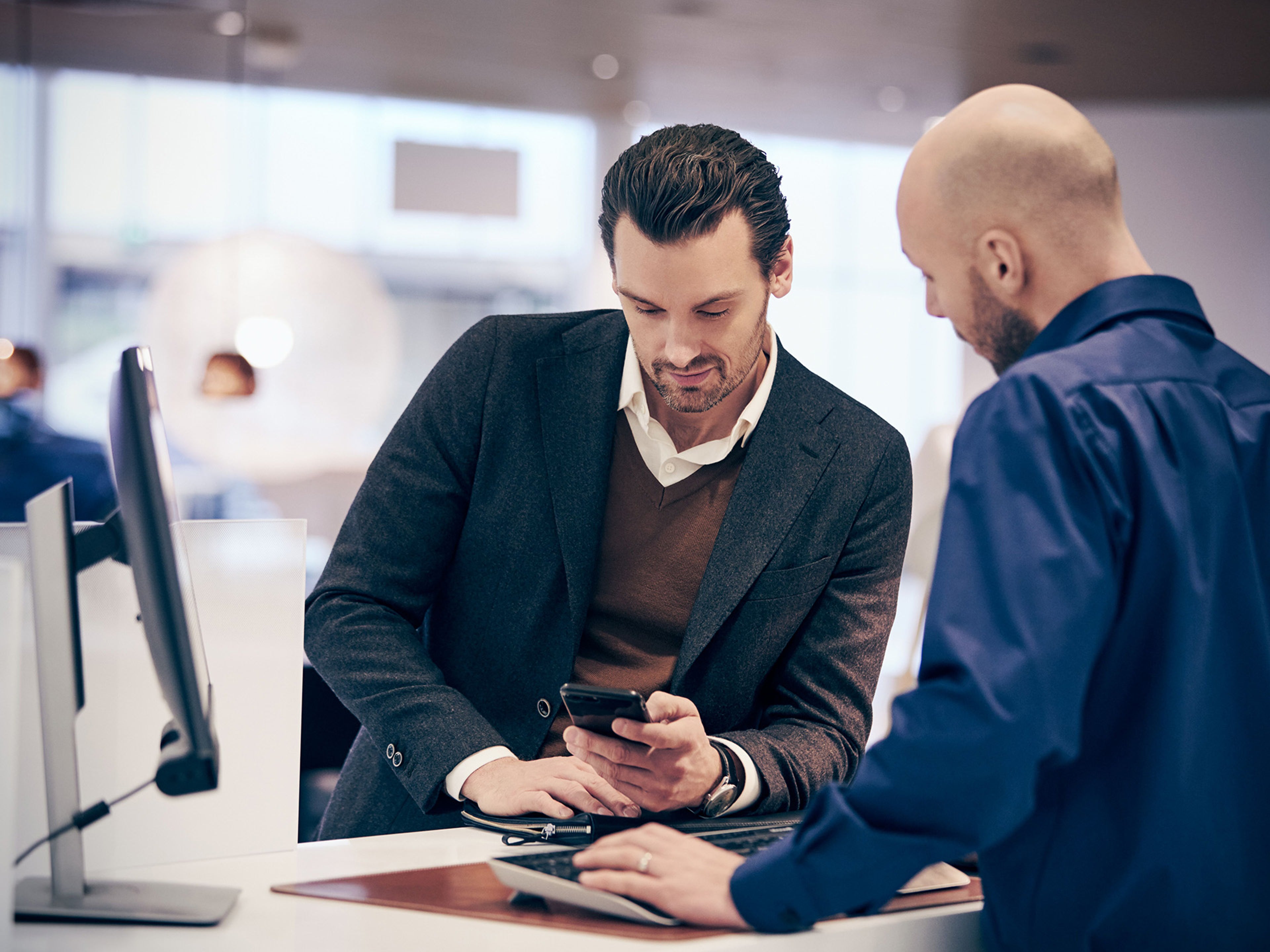Cliente a ser atendido por funcionário volvo num concessionário