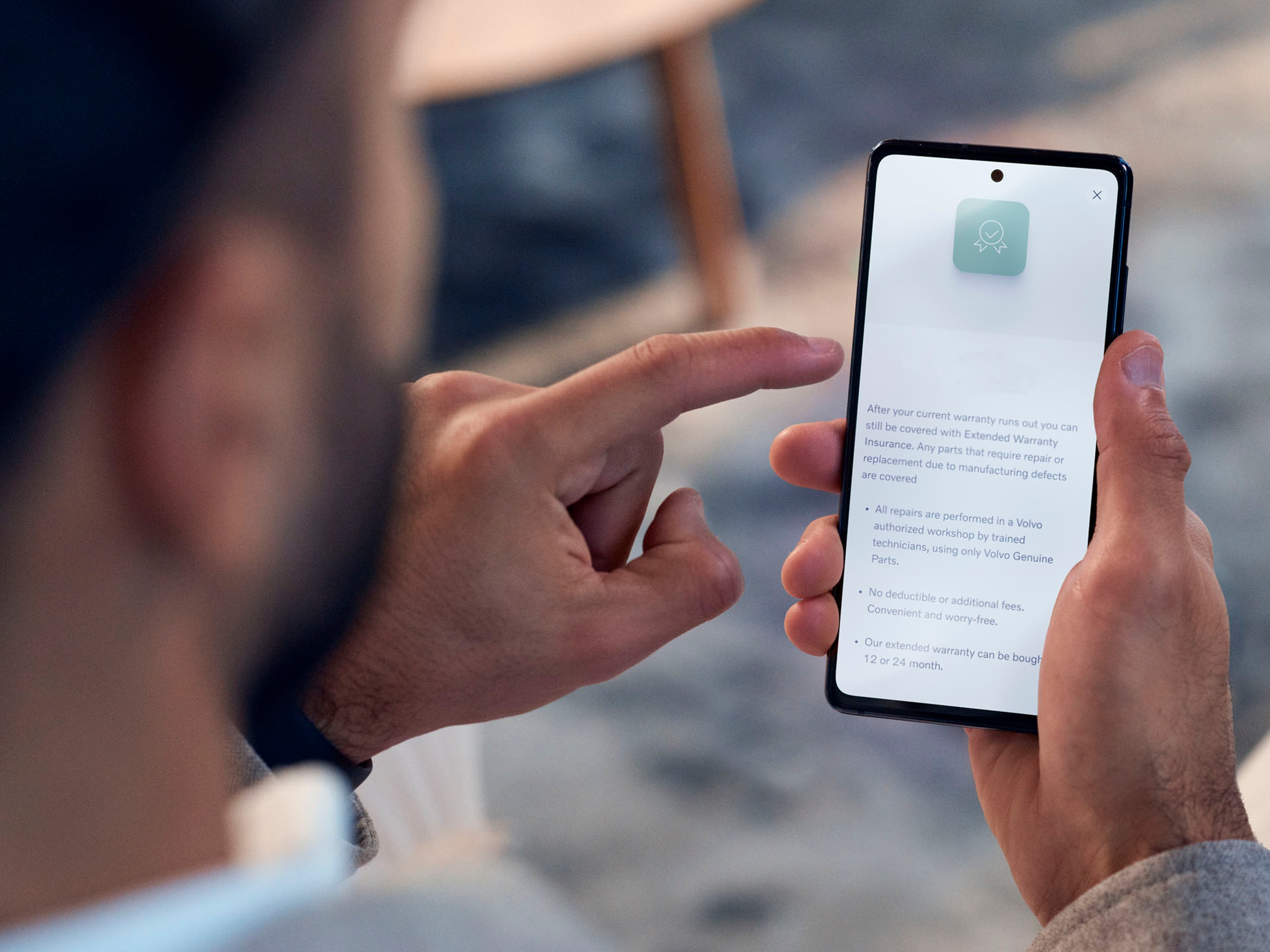 Un hombre consultando en su teléfono móvil las comunicaciones Volvo