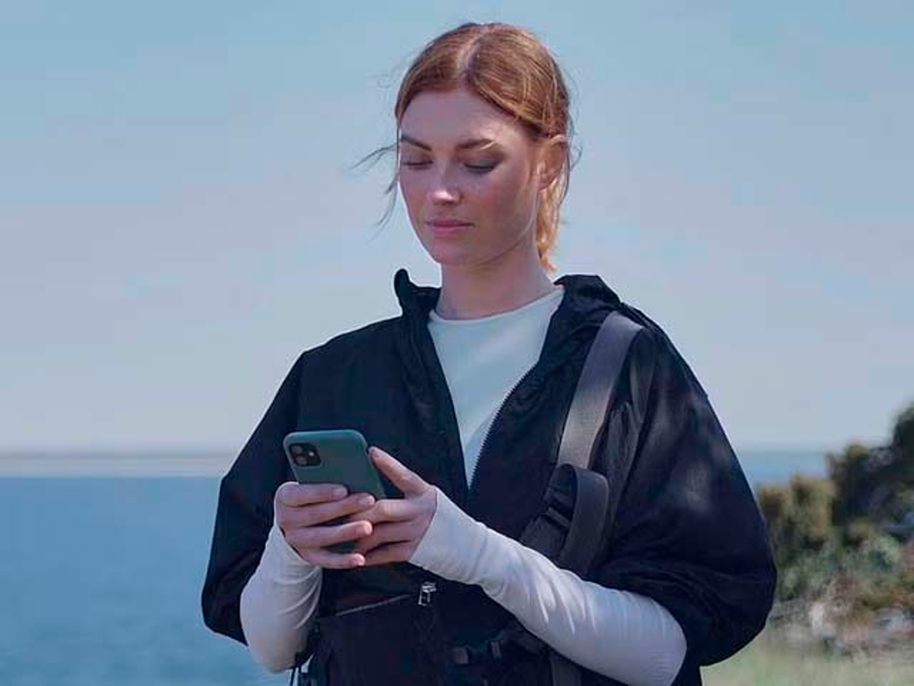 Una chica consultando la aplicación Volvo Cars en su teléfono móvil