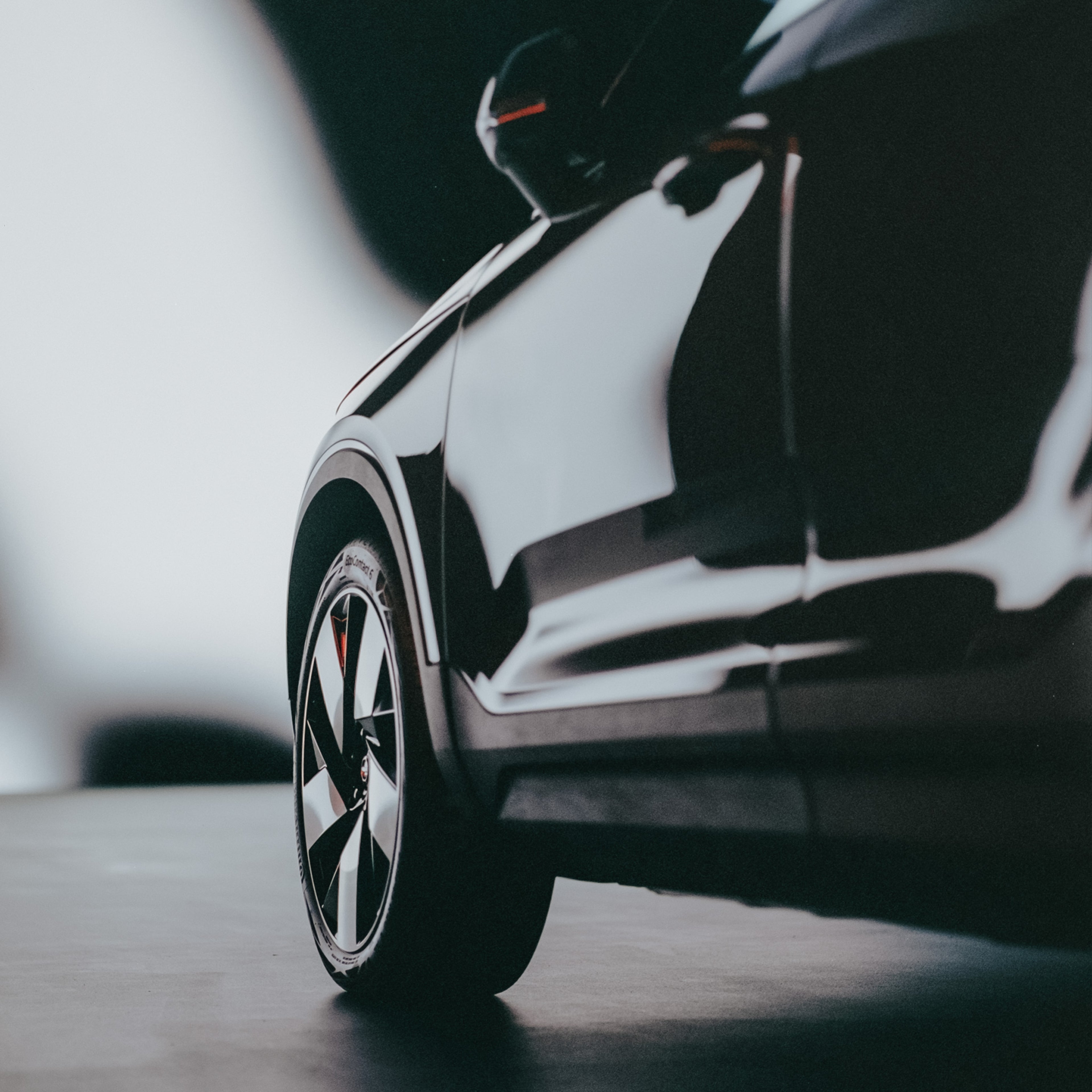 Lähikuva mustan Volvo C40 täyssähköauton vasemmasta kyljestä ja eturenkaasta.