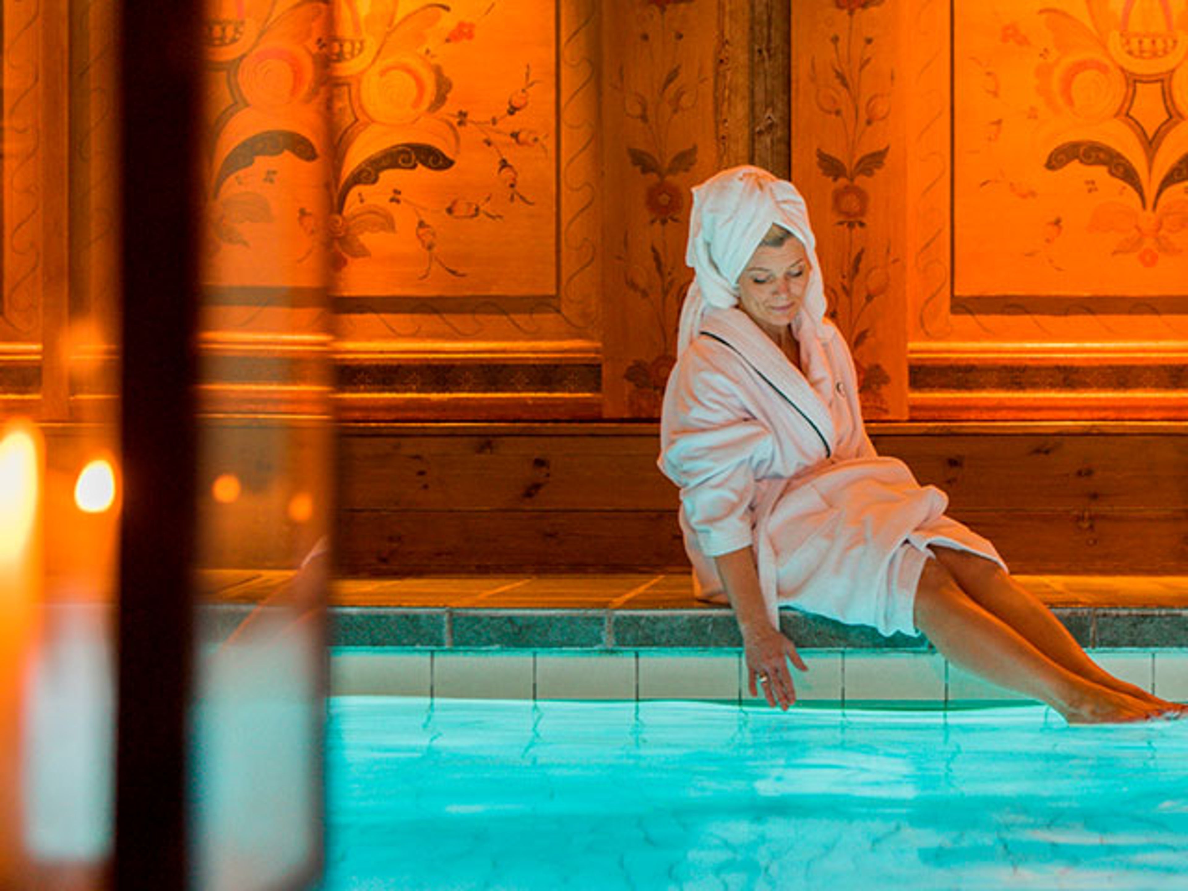 Kvinna sitter vid swimmingpool