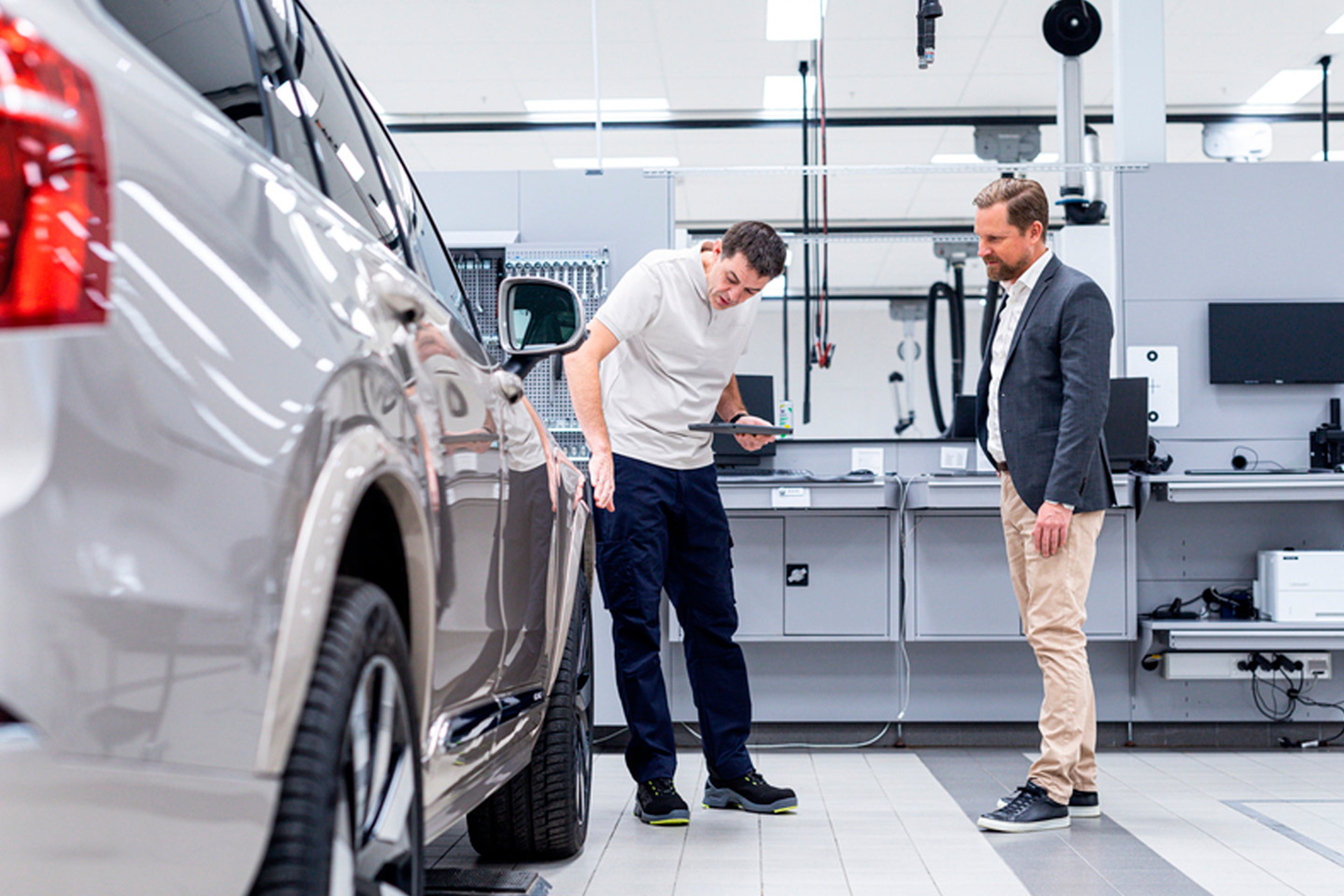 Un técnico Volvo y un usuario inspeccionando un vehículo Volvo