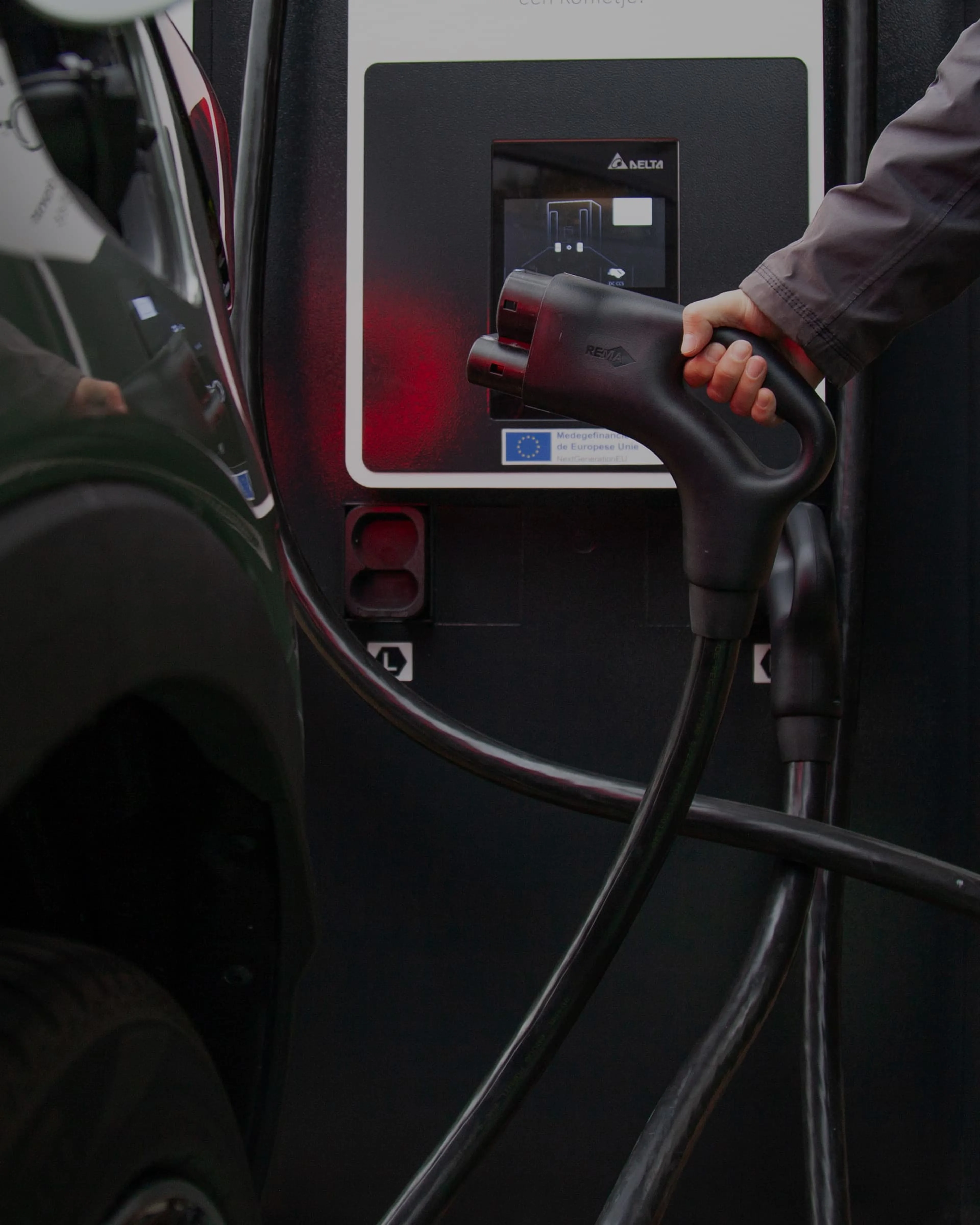 Quelqu'un connecte un câble de charge à une station de charge.