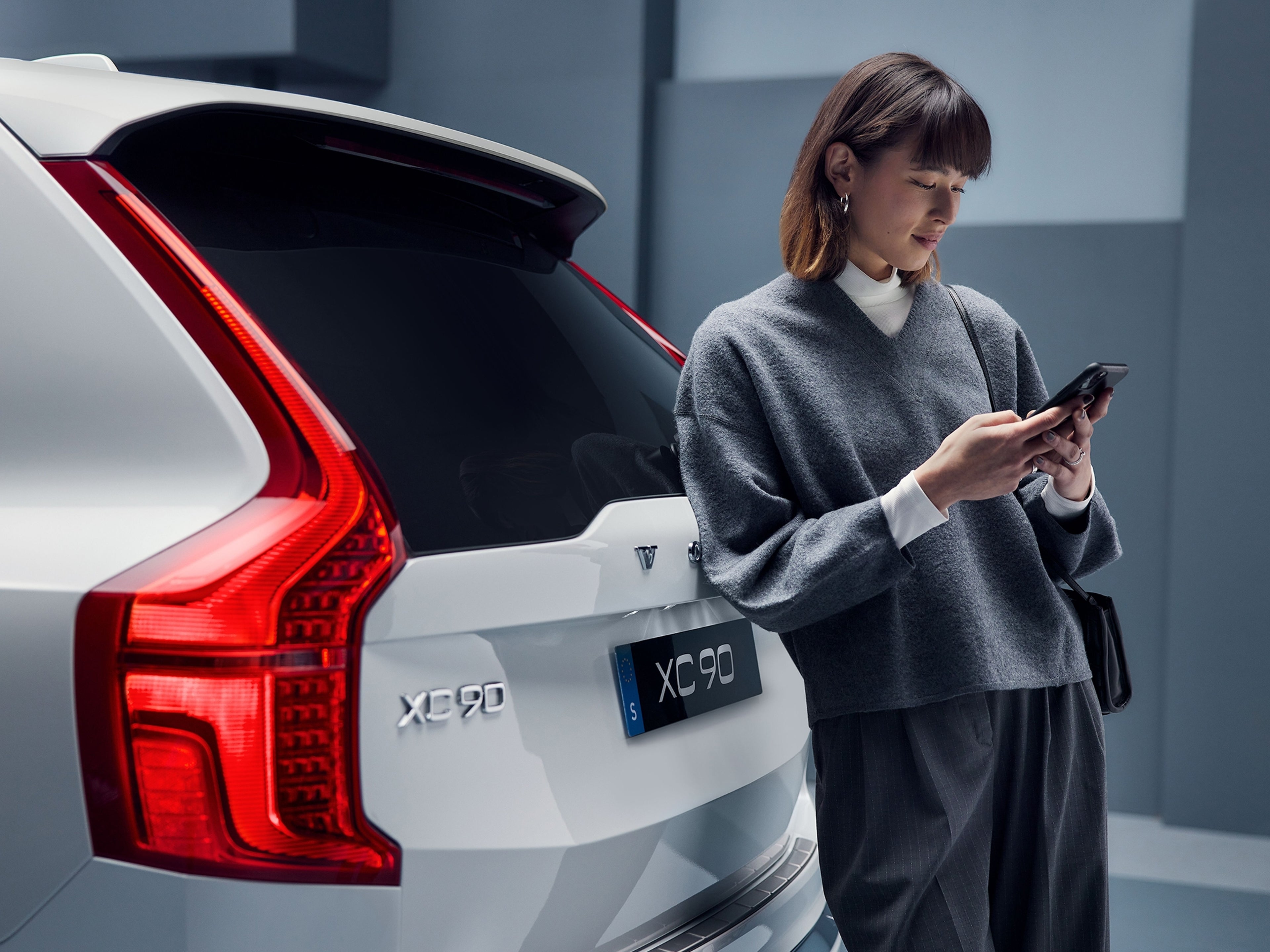 Une femme demande une assistance routière au moyen de son téléphone portable