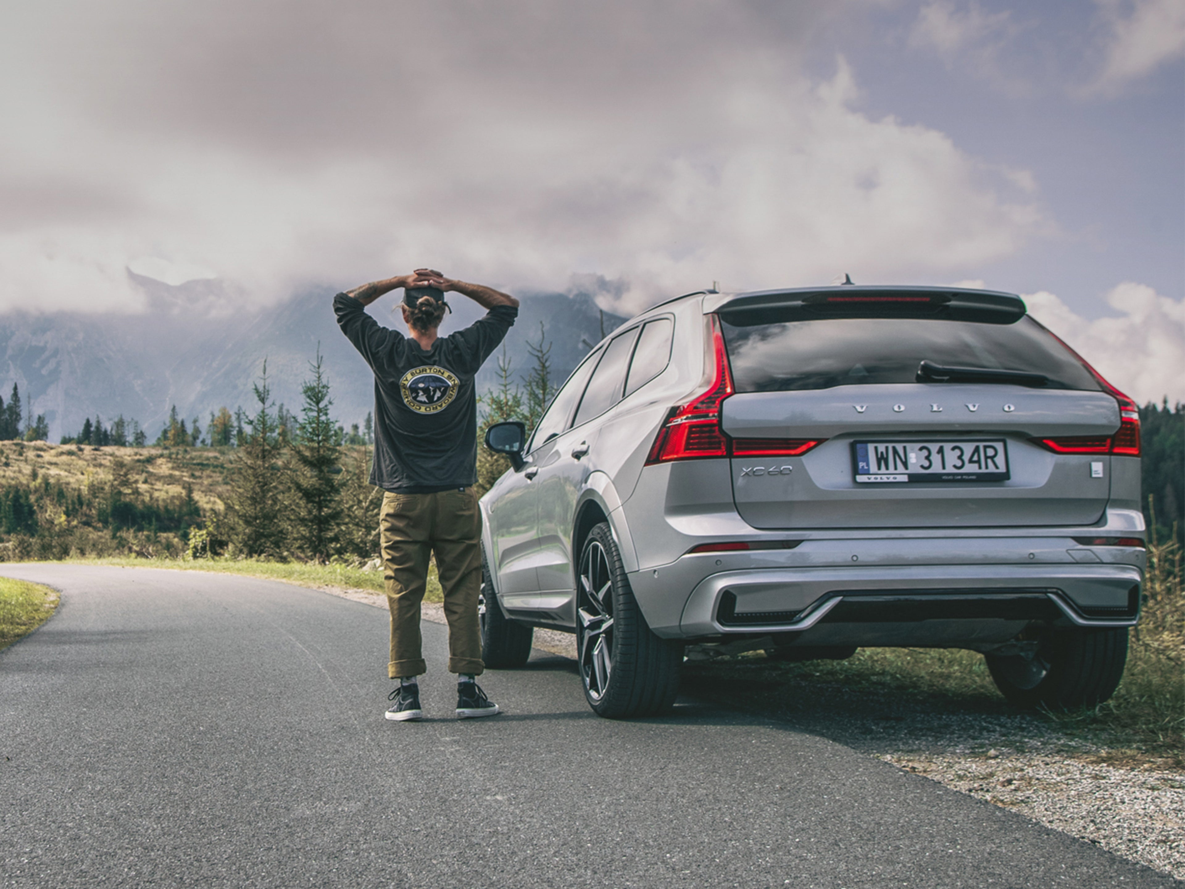 Volvo XC60 na tle gór i osobą stojącą przy samochodzie