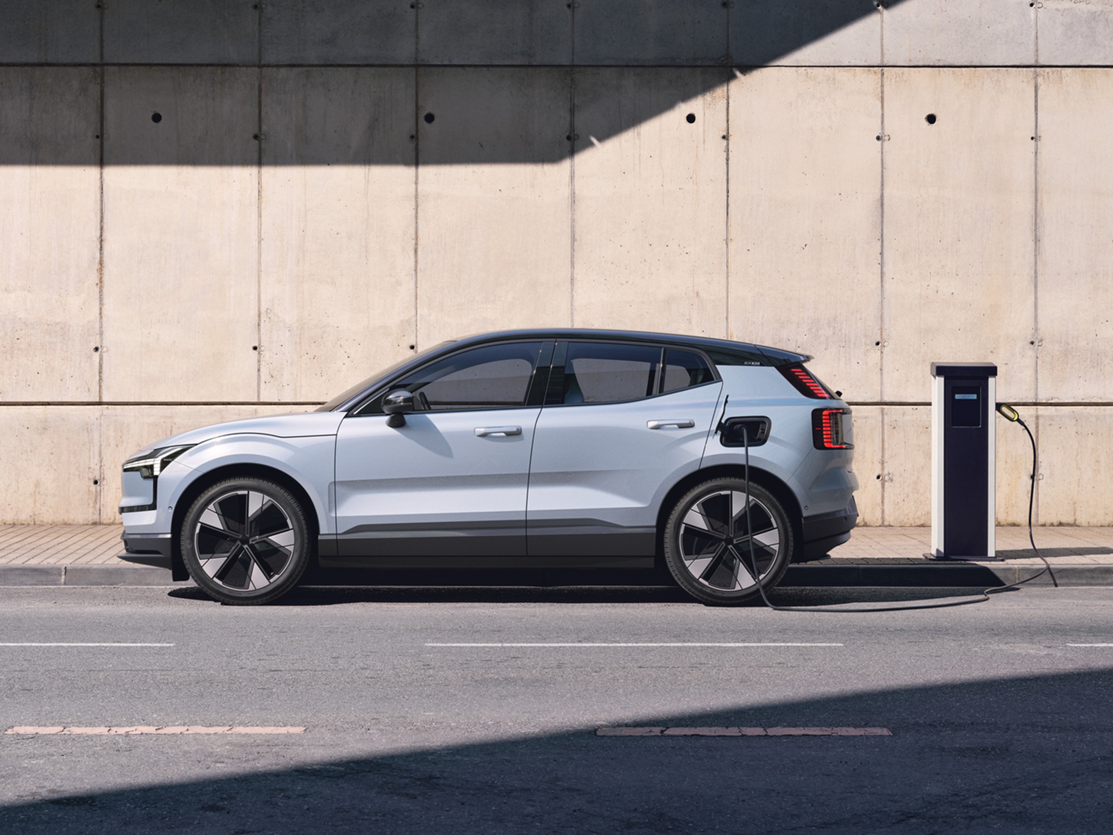 Cloud blue -värinen Volvo EX30 kytkettynä lataukseen.