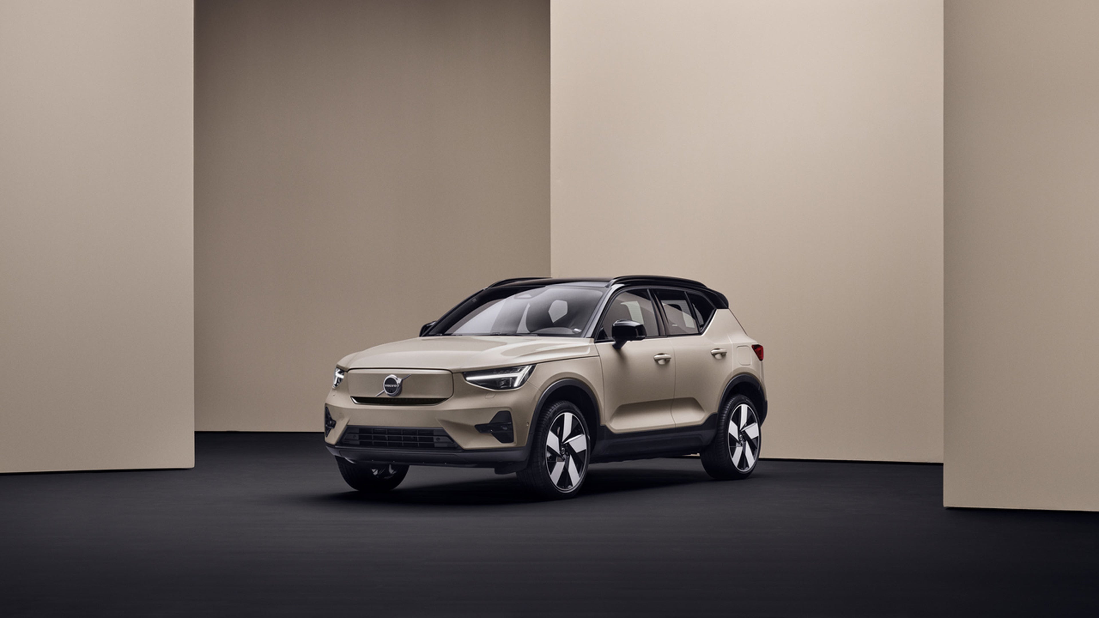 Volvo EX40 beige garé dans une pièce minimaliste aux murs beiges et sol noir