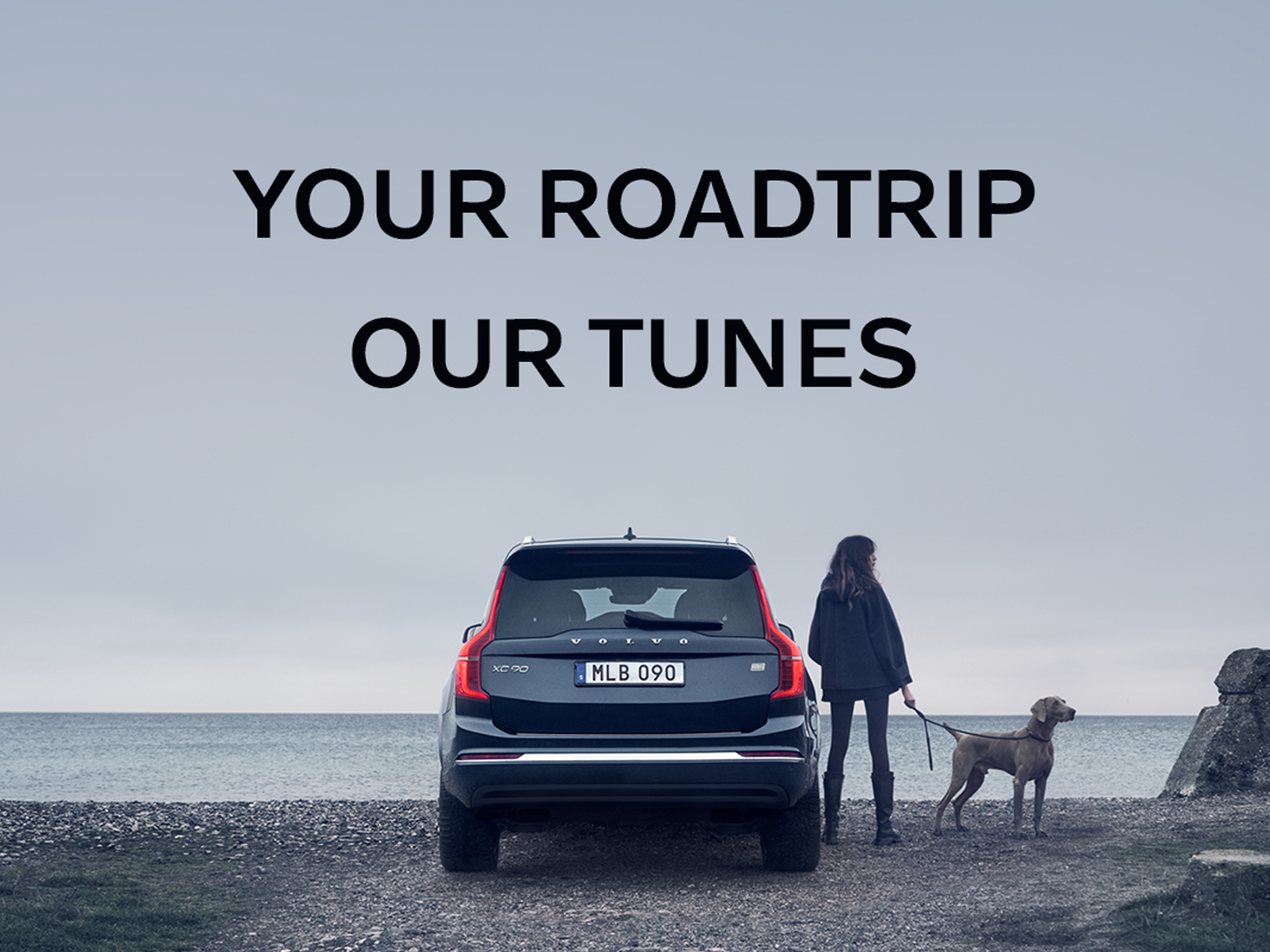 Ein Bild einer Heckansicht eines blauen Volvo XC90. Rechts daneben stehen eine Frau und ihr Hund am Strand. Ein Text über dem Fahrzeug: "YOUR ROADTRIP OUR TUNES"