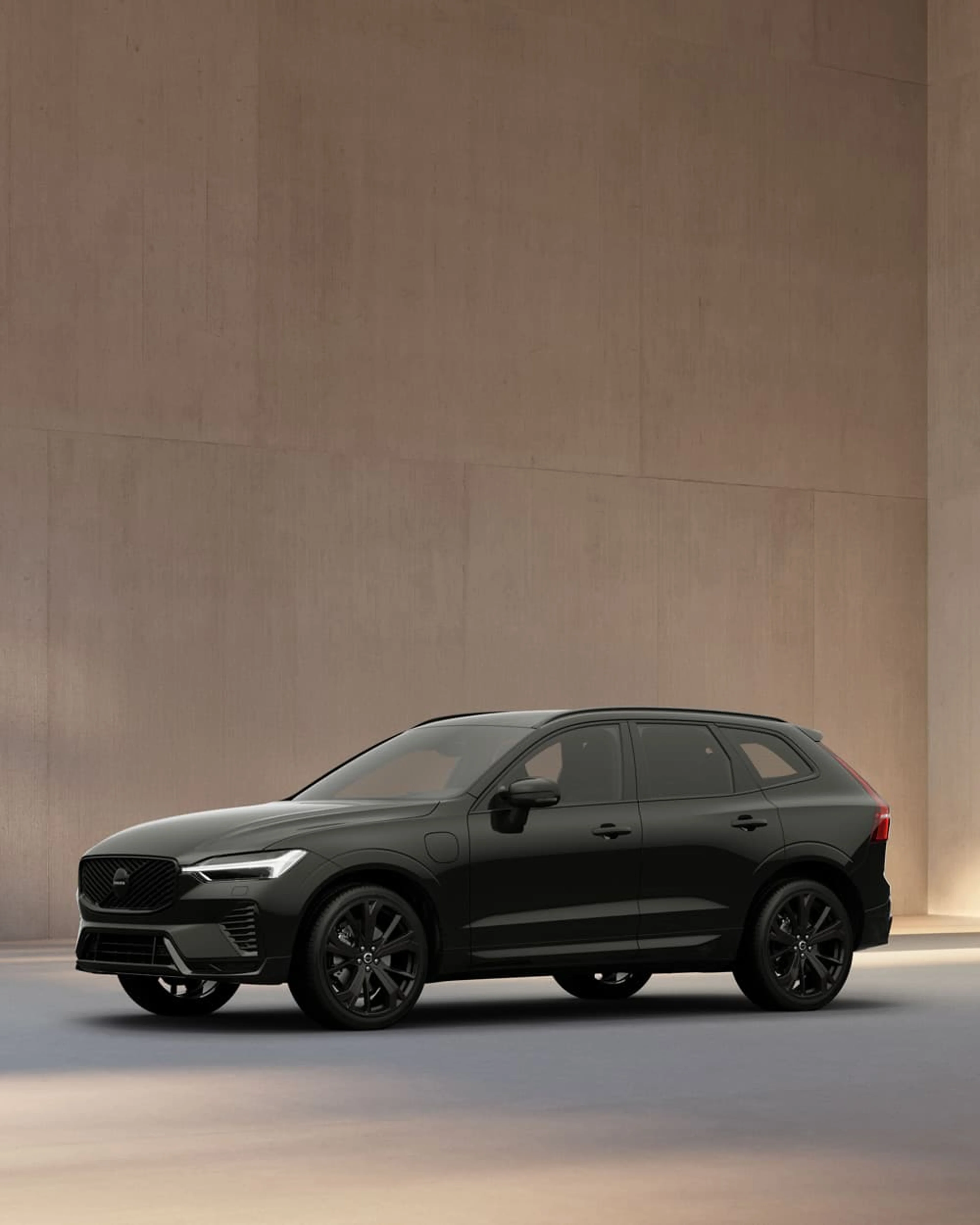 Volvo XC60 Black Edition geparkeerd aan de kant van water.