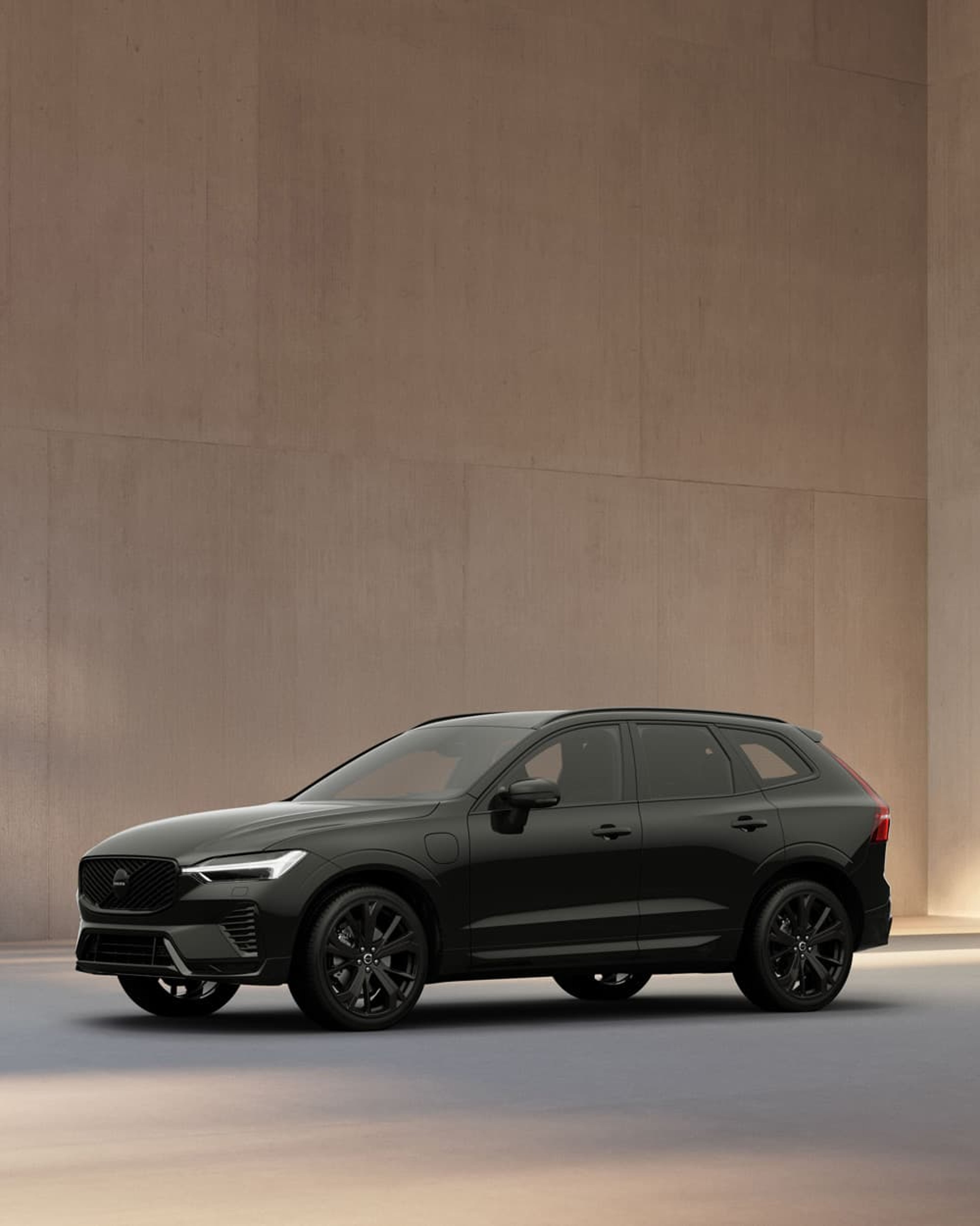 Volvo XC60 Black Edition geparkeerd aan de kant van water.