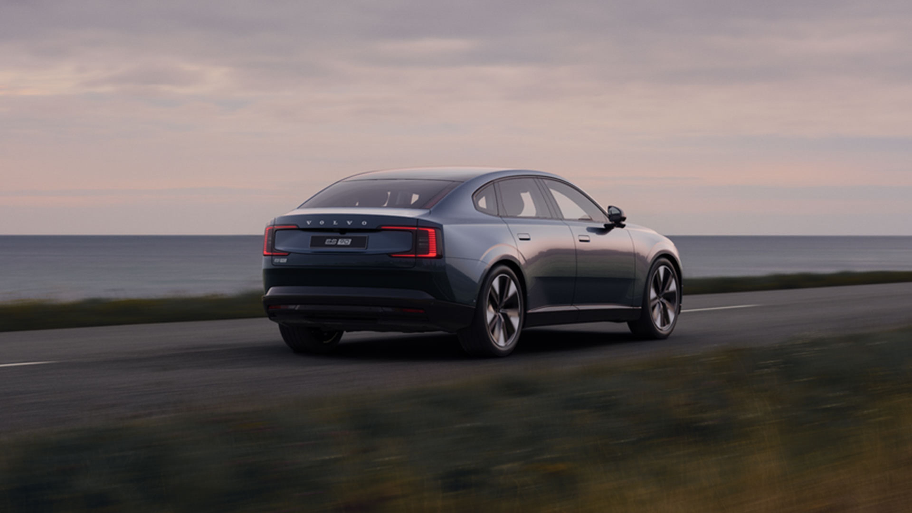 Vue de ¾ arrière d’une ES90 sur une route côtière.