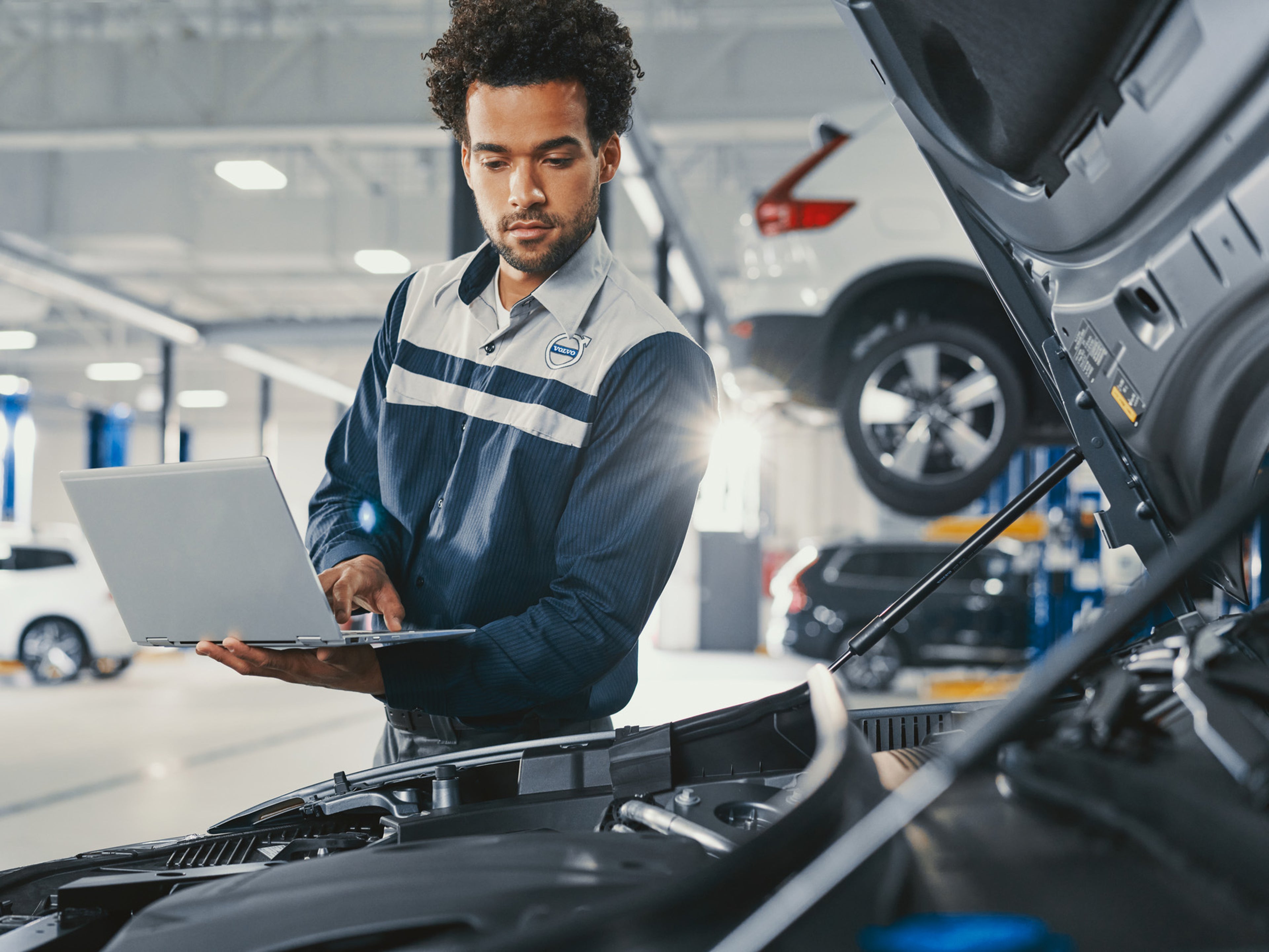 Volvo technician inspecting Volvo car using computer