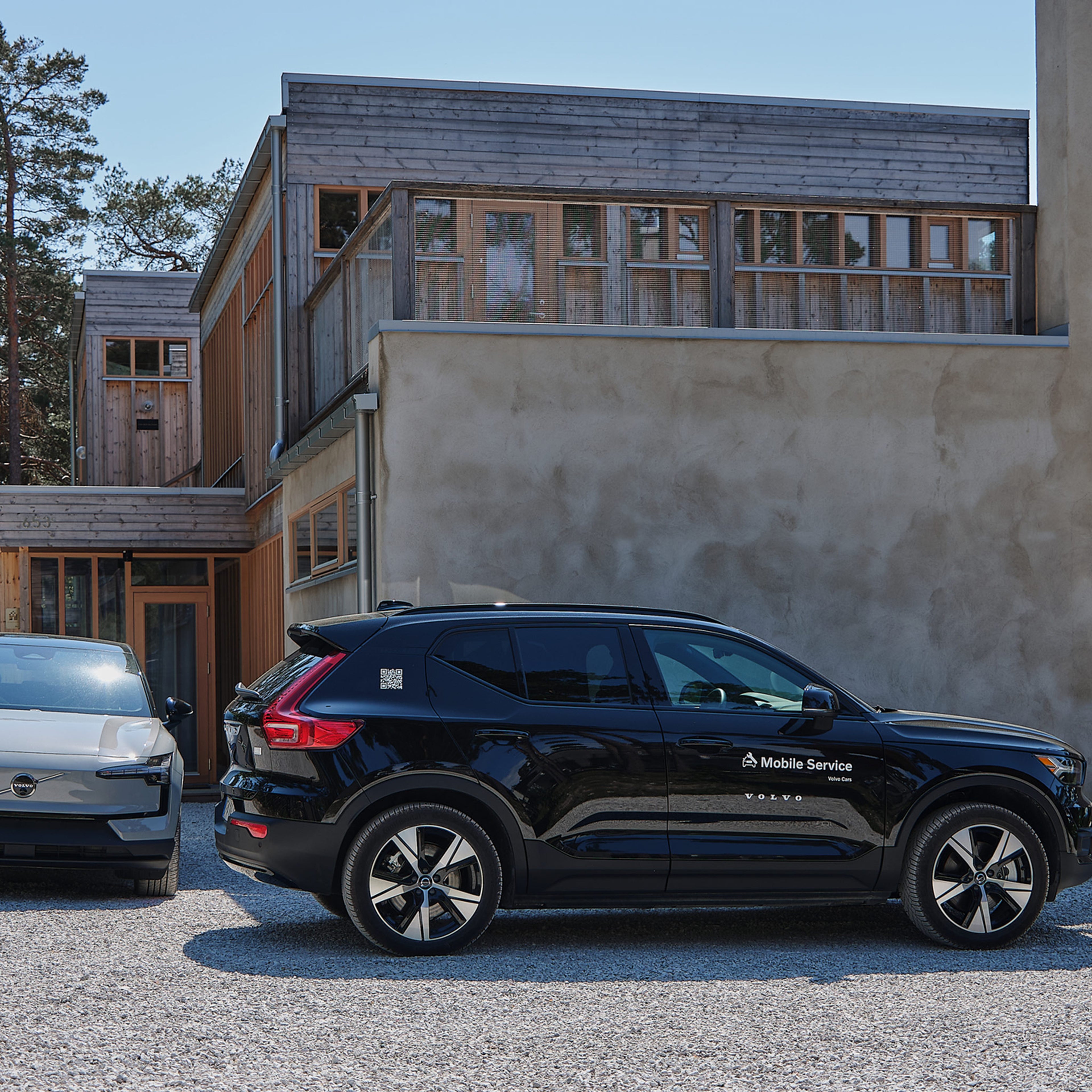 Volvo EX30 ja Volvo Mobile Service huoltoauto pihatielle pysäköitynä.