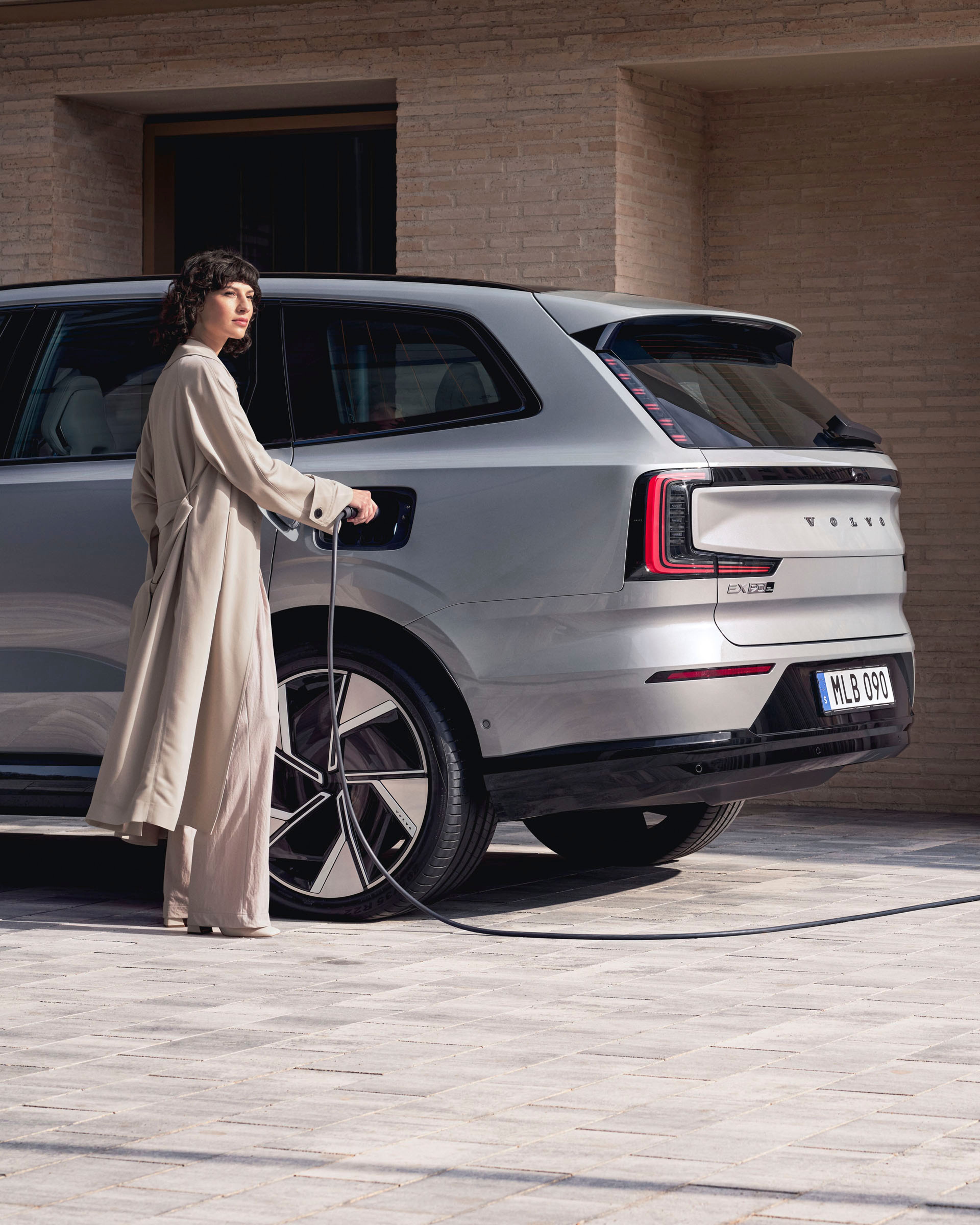 Mujer cargando un Volvo EX90 eléctrico