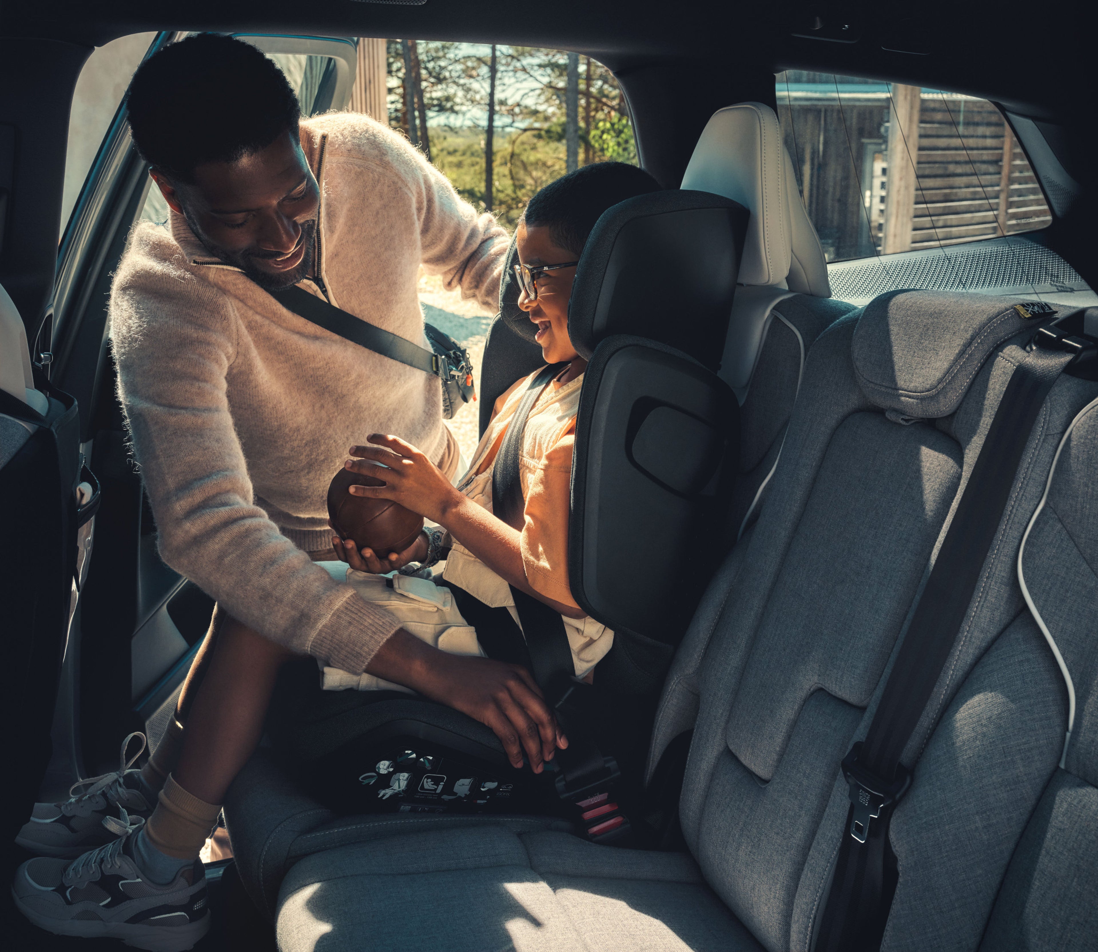 Eine Mutter schnallt ihr Kind in einen Volvo Kindersitz mit Booster.