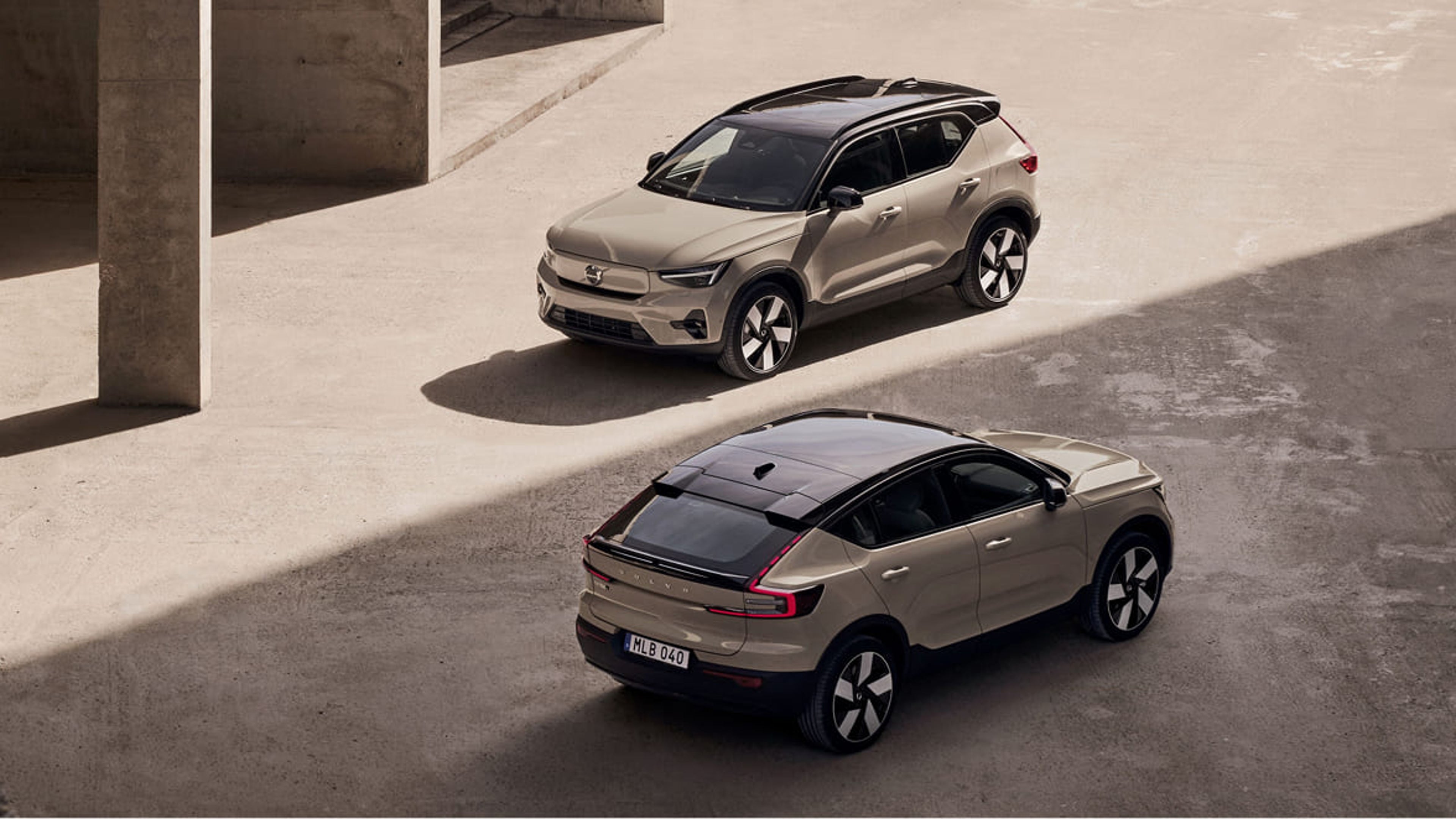 Volvo EX40 och EC40 parkerade diagonalt mot varandra i en betongmiljö