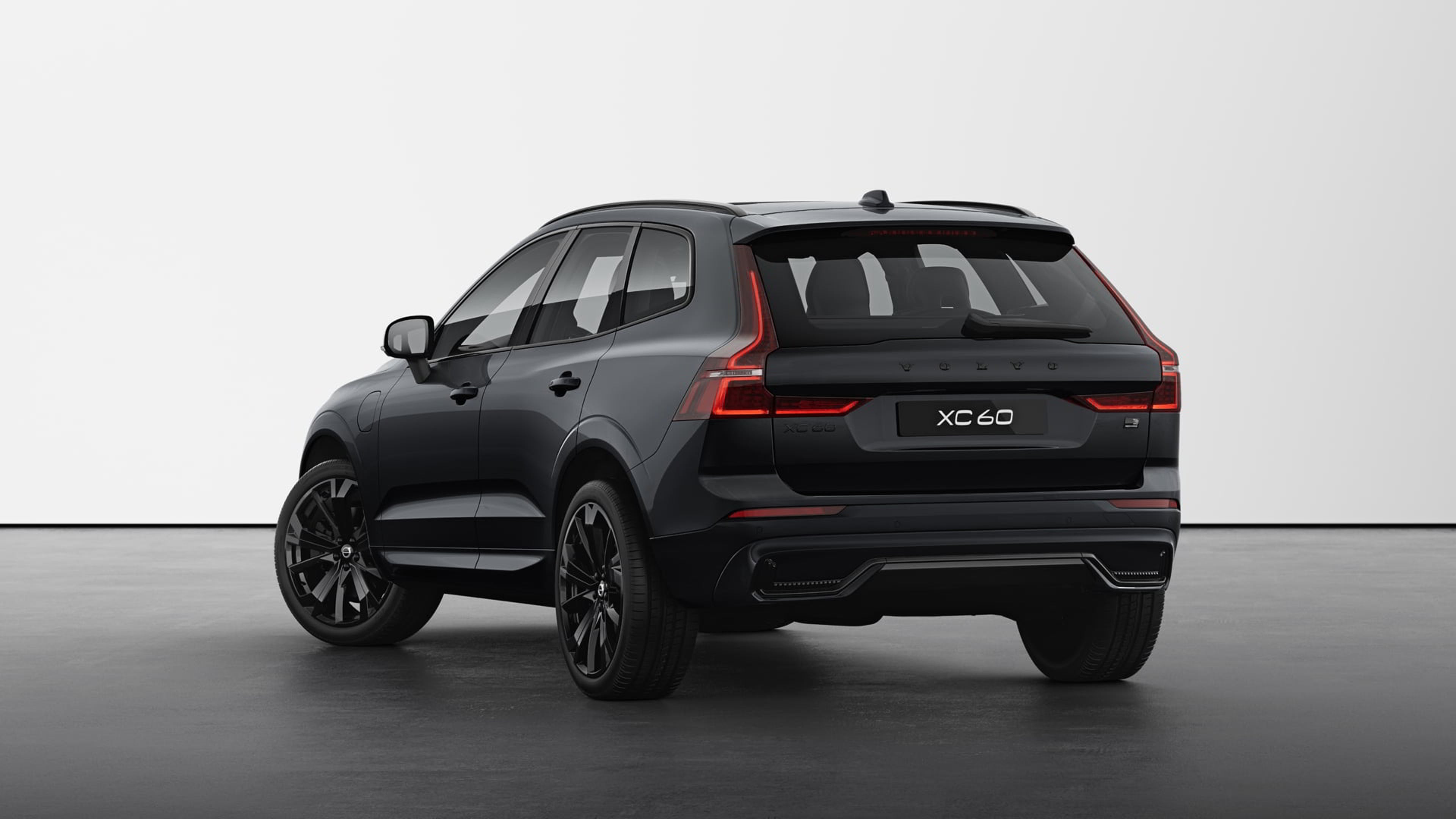 Vue arrière d’une Volvo XC60 Black Edition dans un décor de studio minimaliste