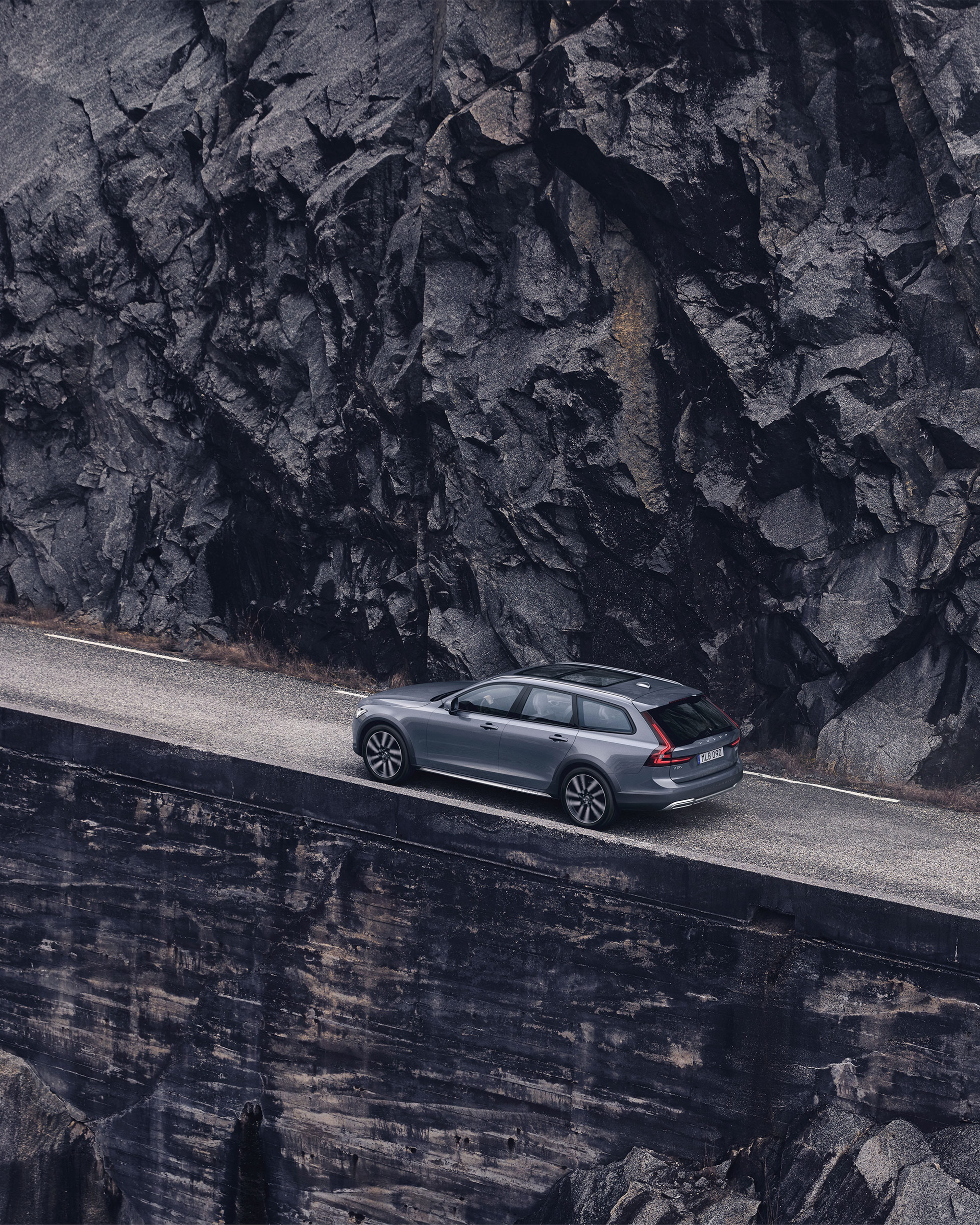 Grå Volvo vid bergsvägg