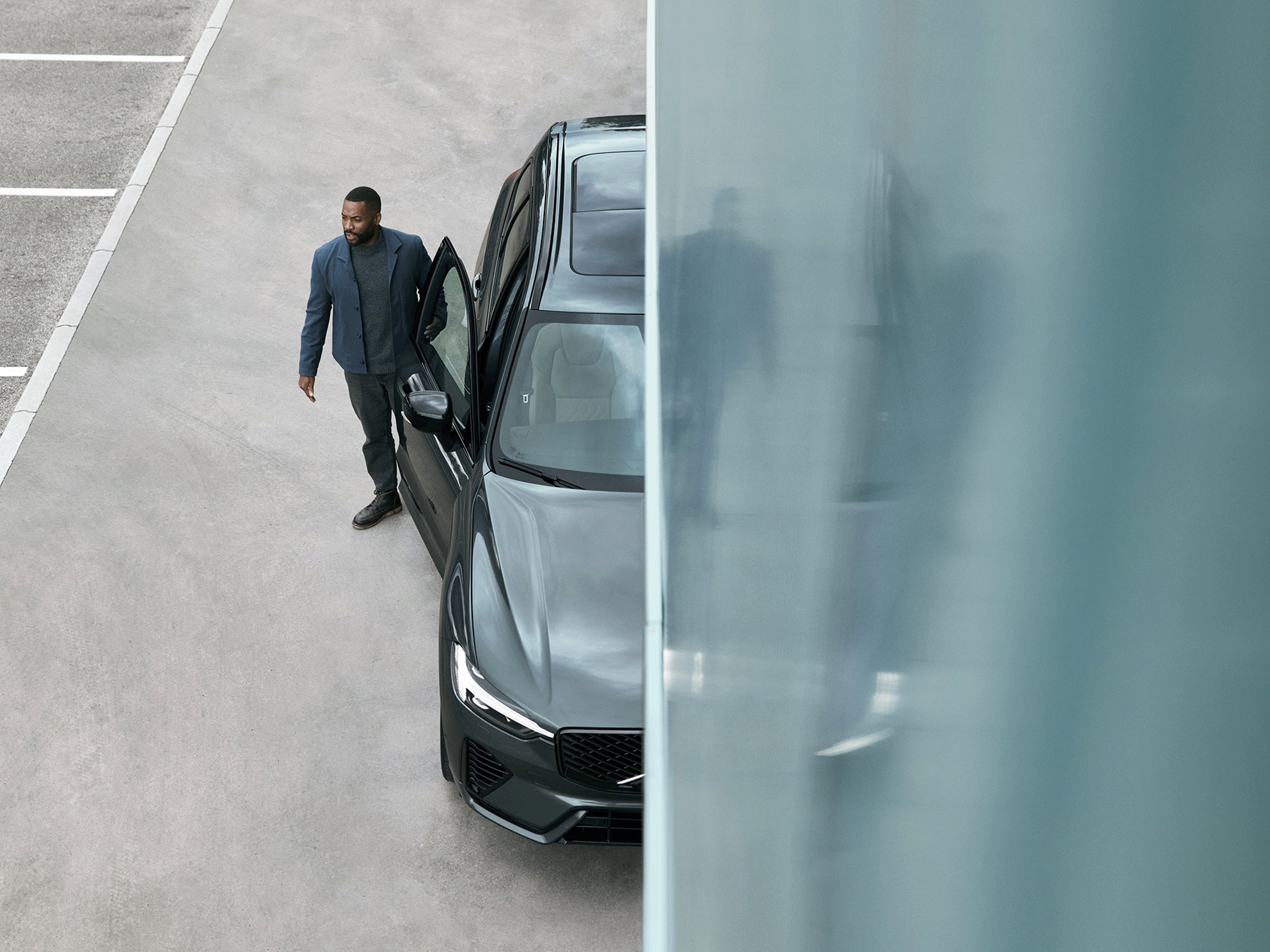 Ein Mann steht neben einem Volvo XC60.
