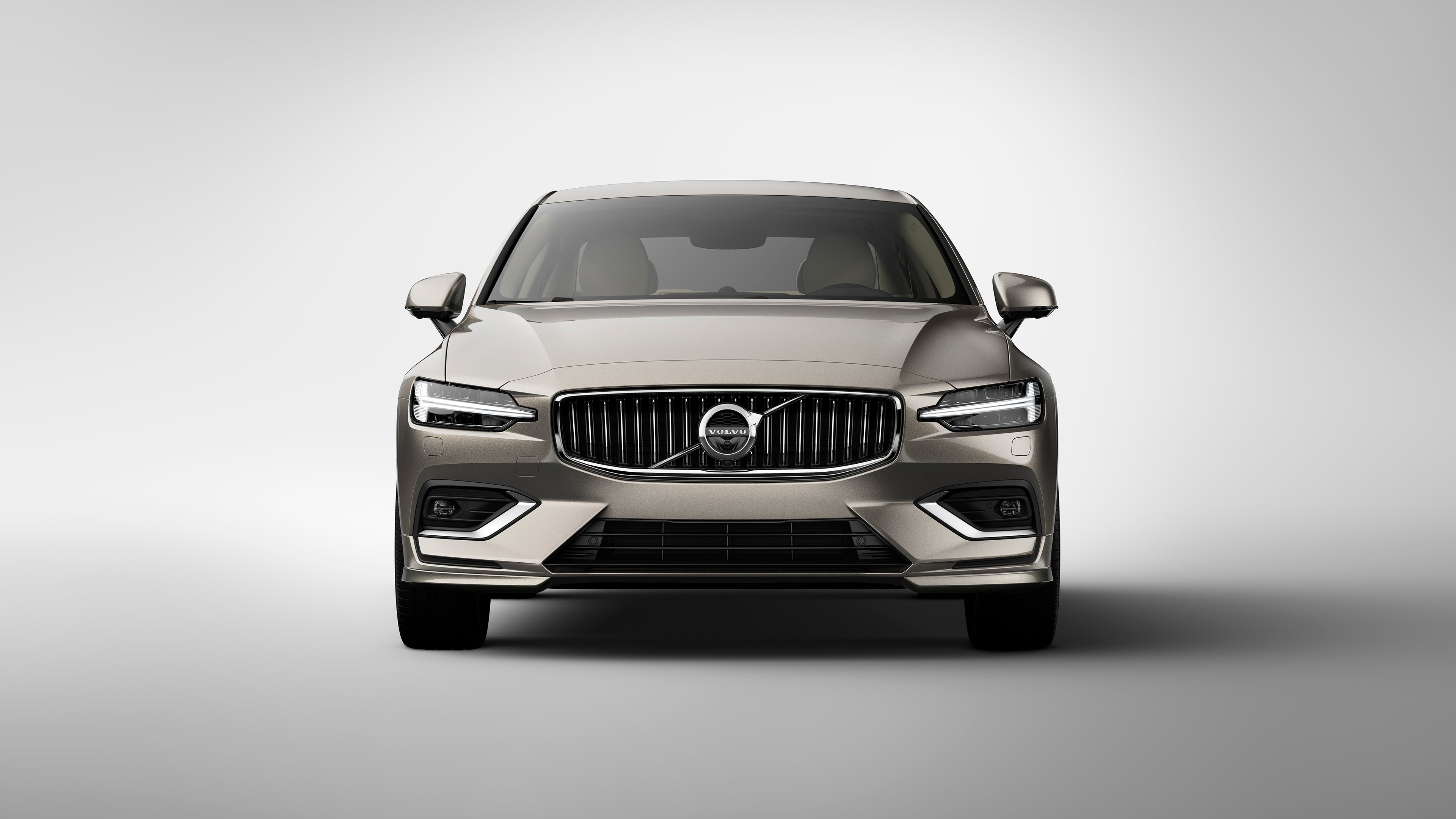 Vue avant d’une berline Volvo S60 argentée avec calandre proéminente et phares effilés sur fond blanc