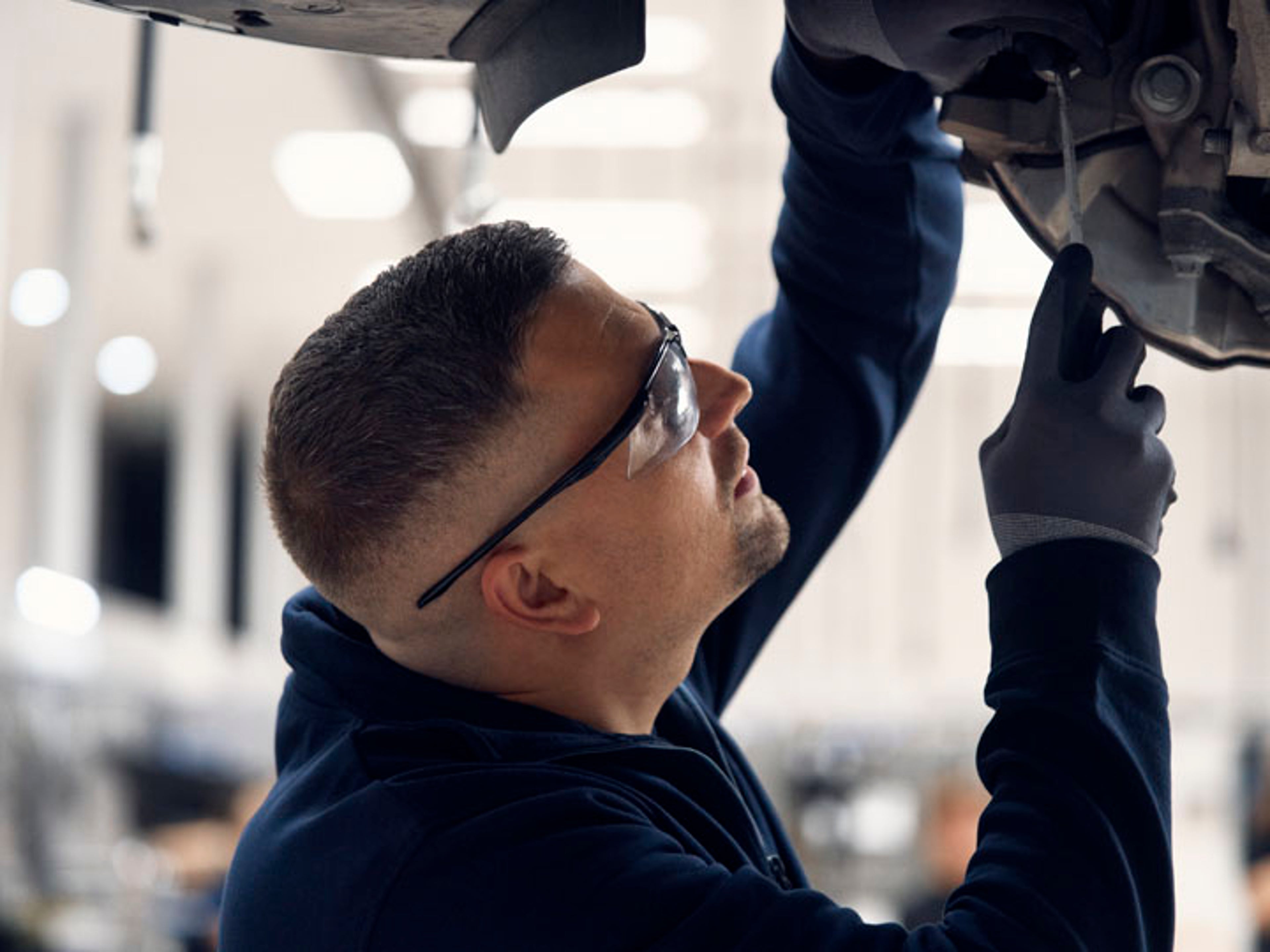 Un mecánico Volvo haciendo una comprobación en los bajos de un vehículo