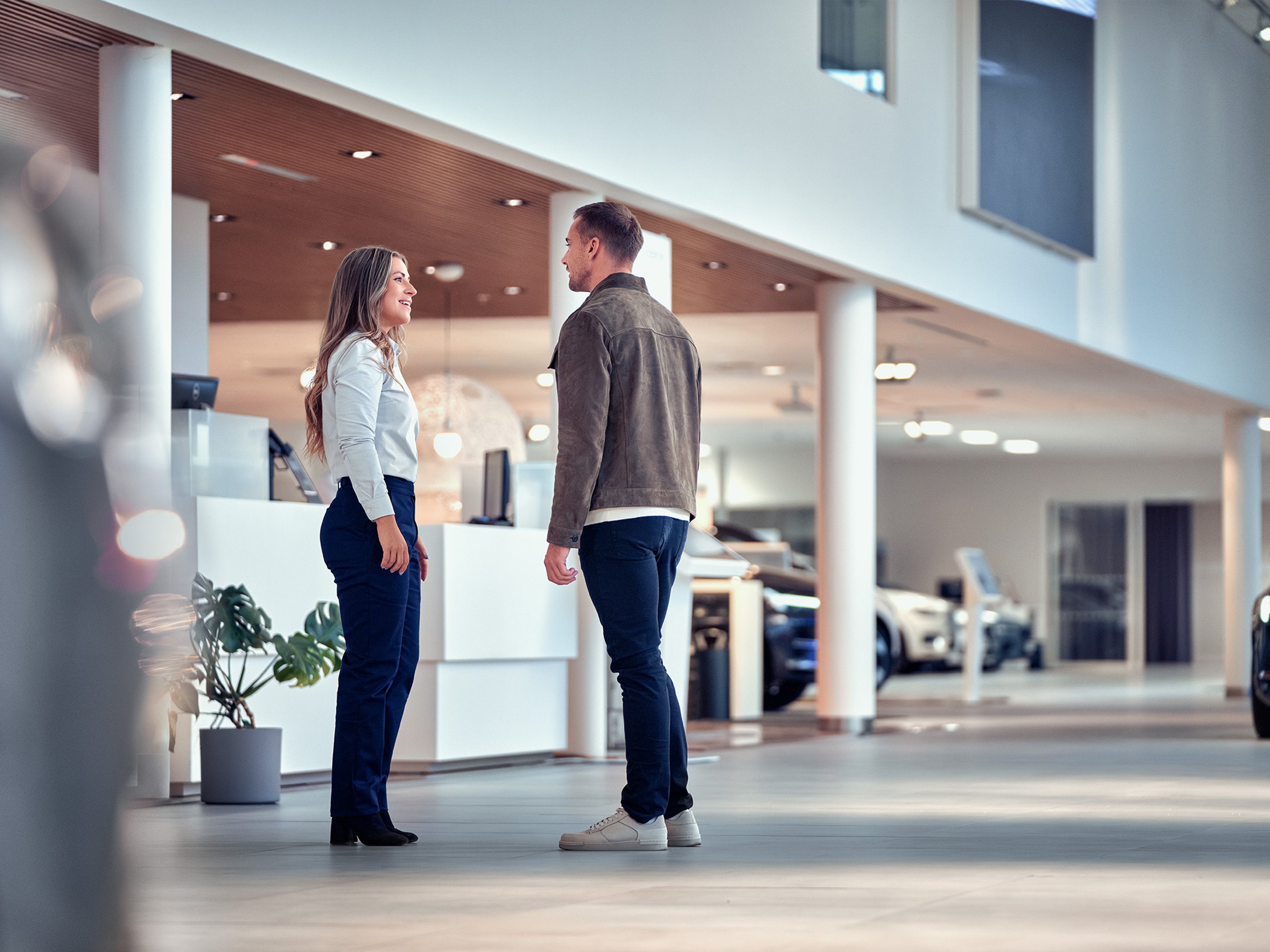 Volvon myyjä keskustelee asiakkaan kanssa Volvon liikkeessä.