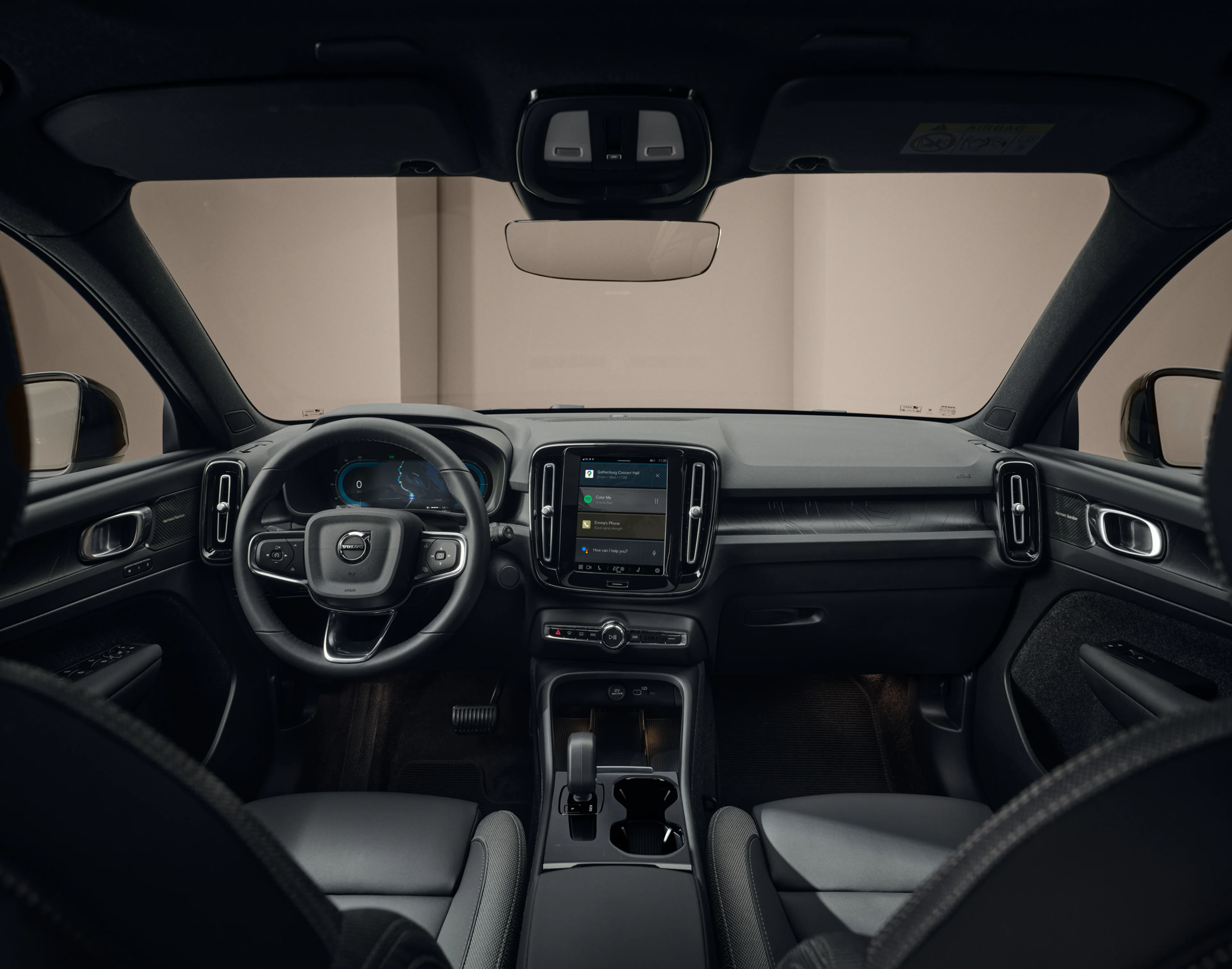 Intérieur de voiture avec volant, tableau de bord numérique et écran tactile affichant navigation et divertissement