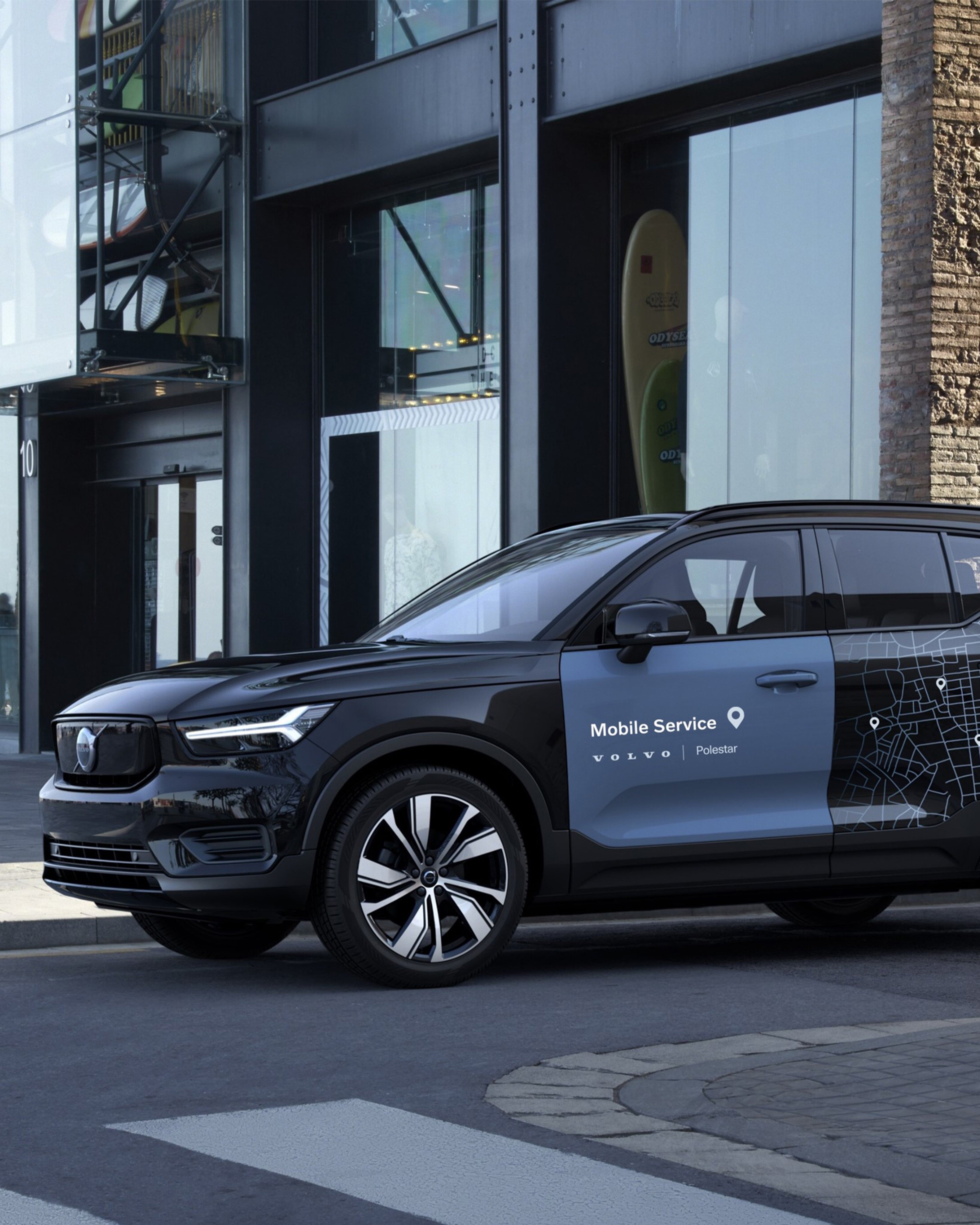 Svart Volvo med Mobile Service-logo på sett fra siden