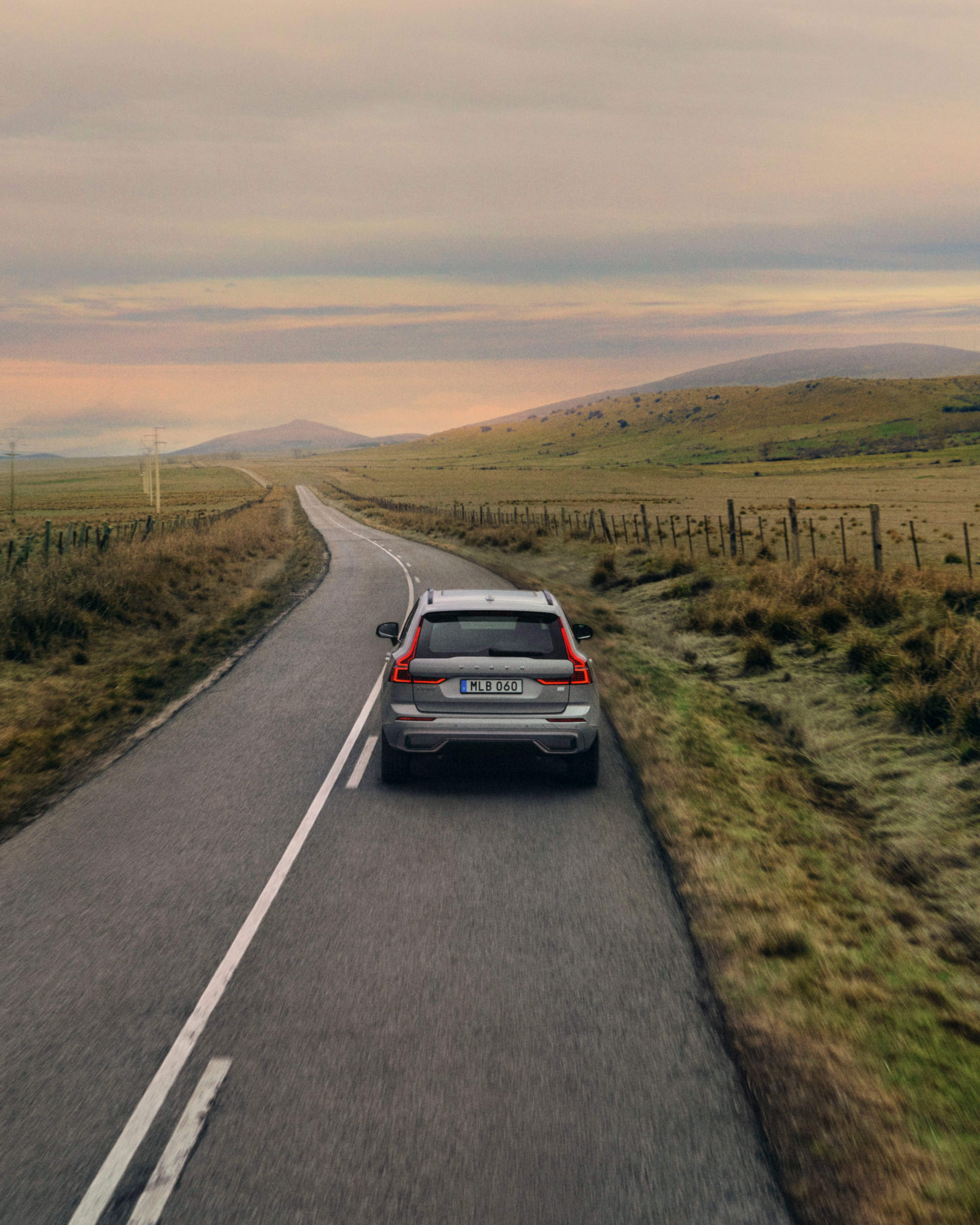 Un Volvo familiar viajando por una carretera en el campo