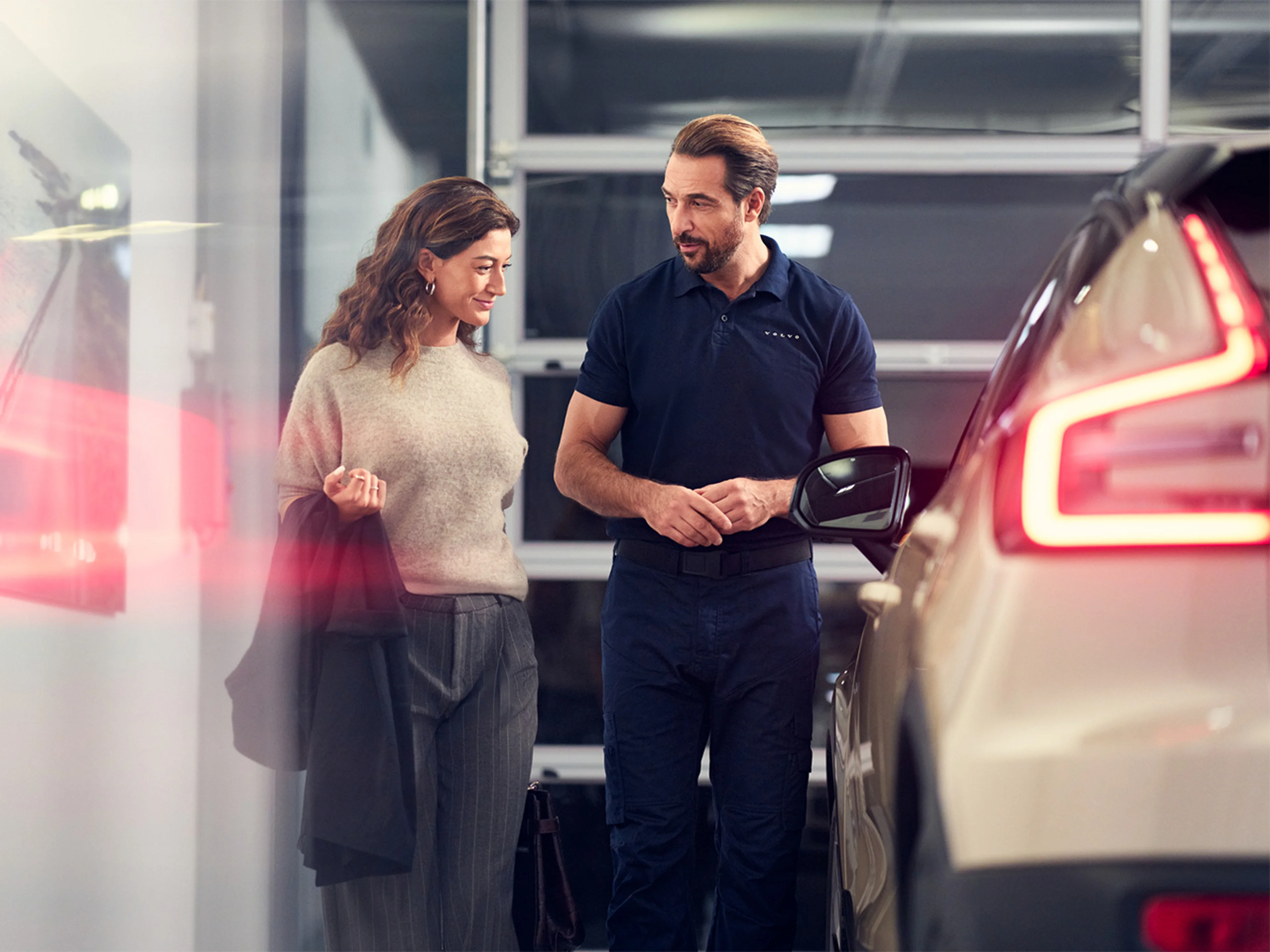 A customer speaking with a Volvo technician in a Volvo retailer.