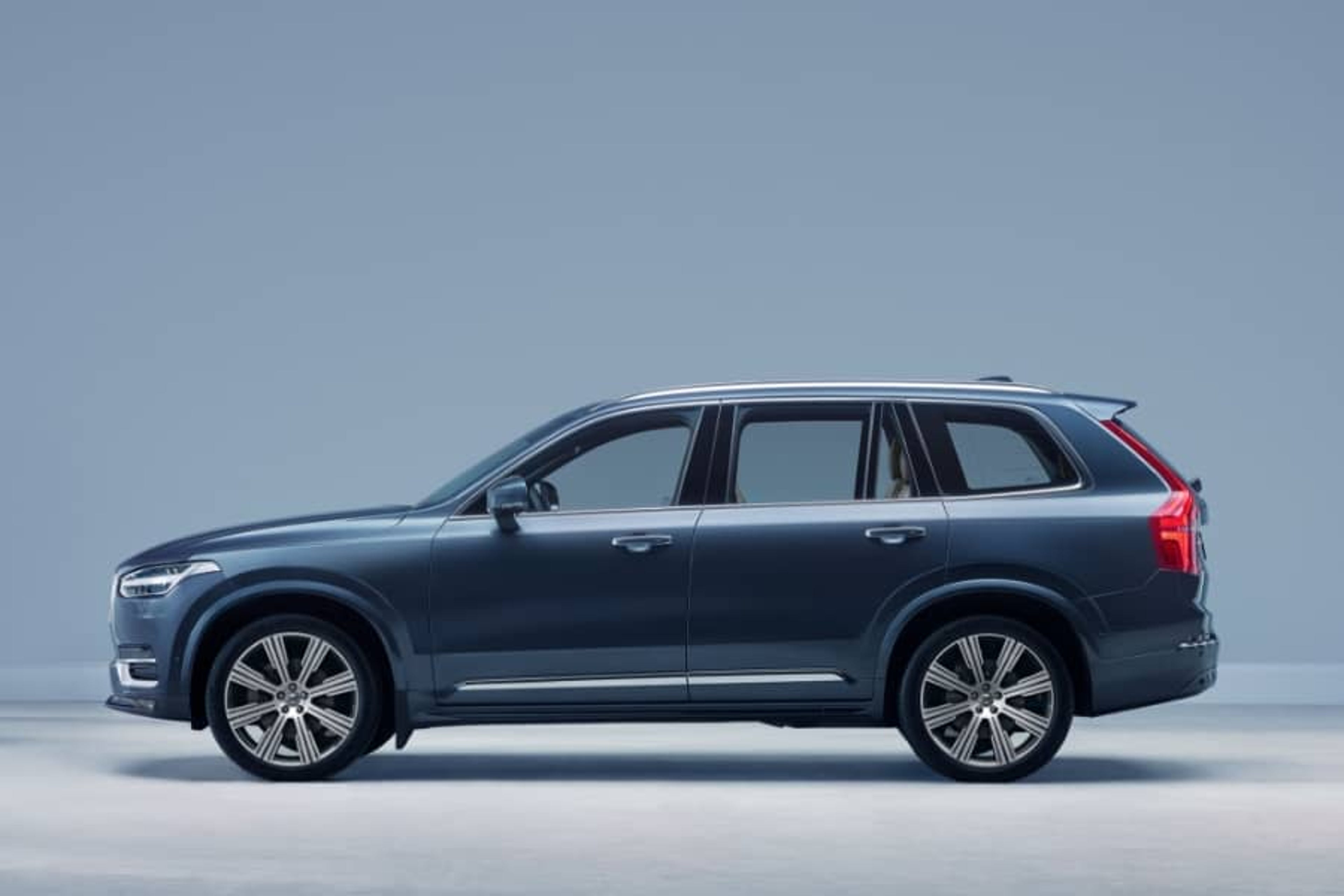 Volvo XC90 u plavoj boji, bočni pogled na svijetloj pozadini.