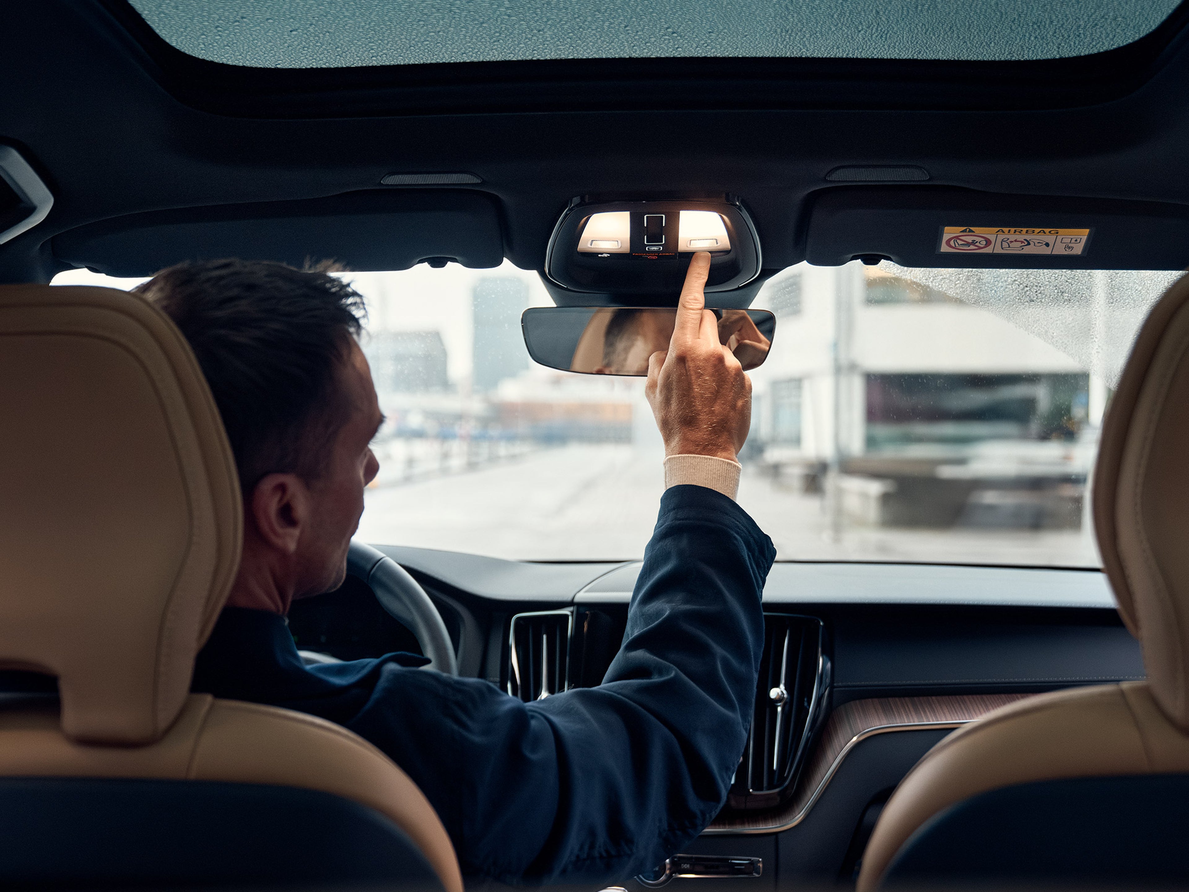 Kuskin paikalla istuva mies painamassa Volvo On Call nappia.