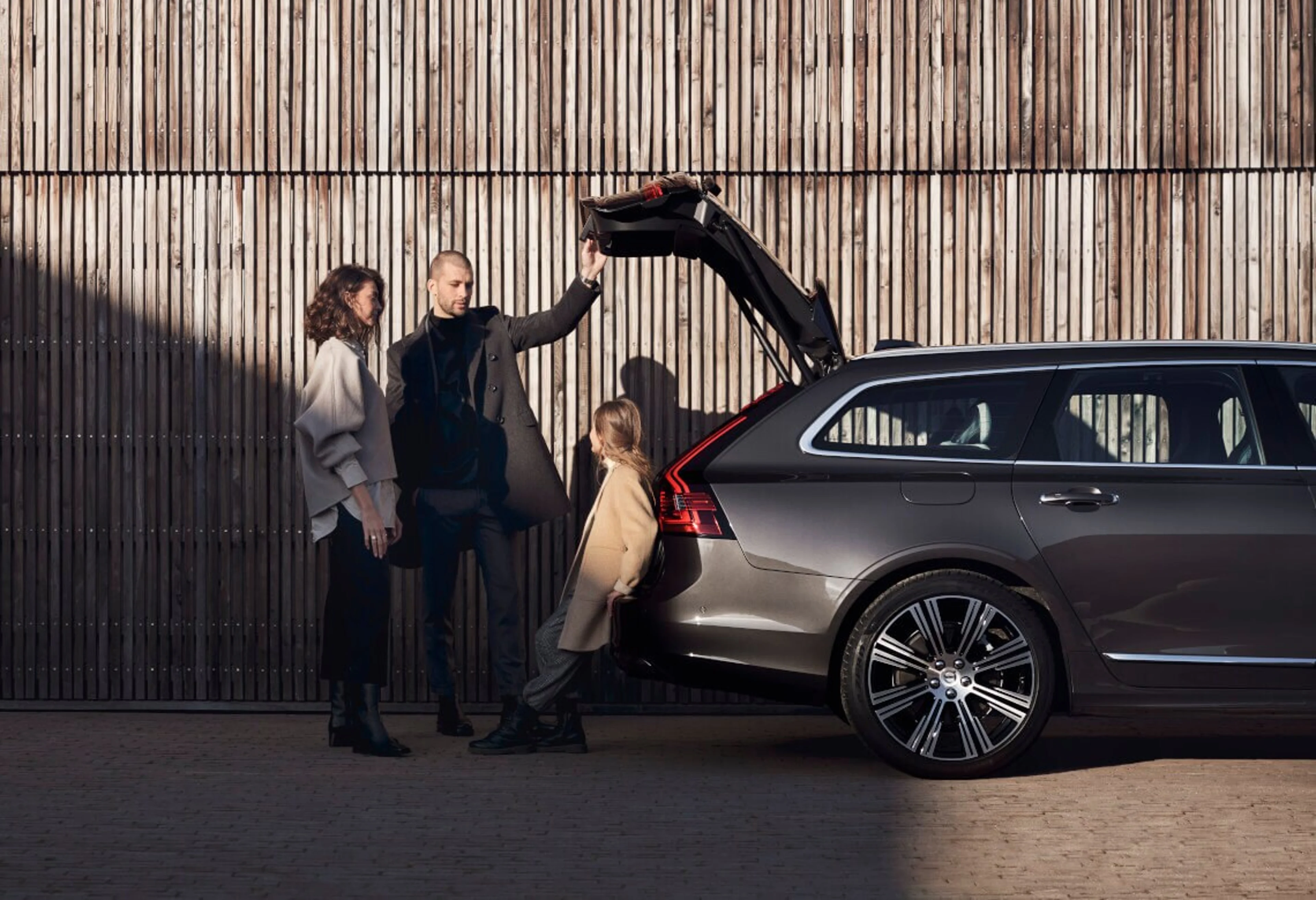 Drei Personen stehen am geöffneten Gepäckraum eines Volvo V90