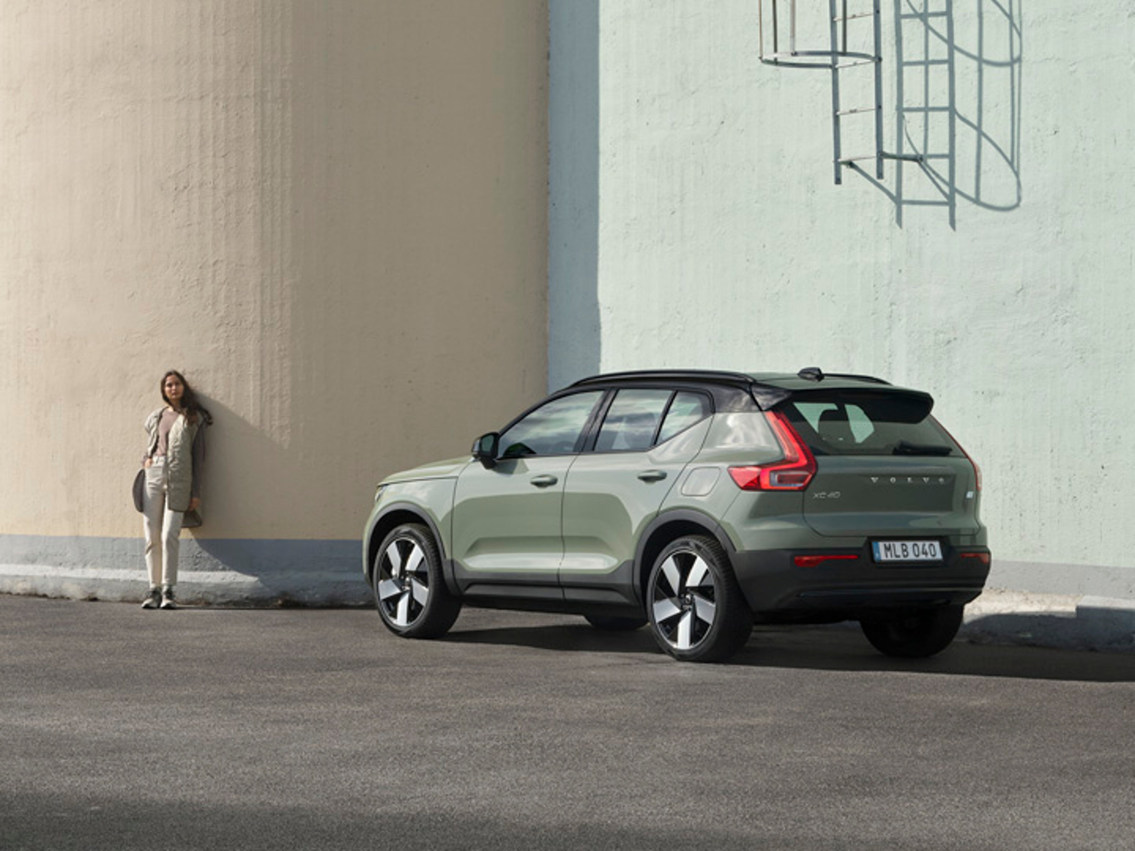Volvo XC40 y una chica al lado apoyada en la pared
