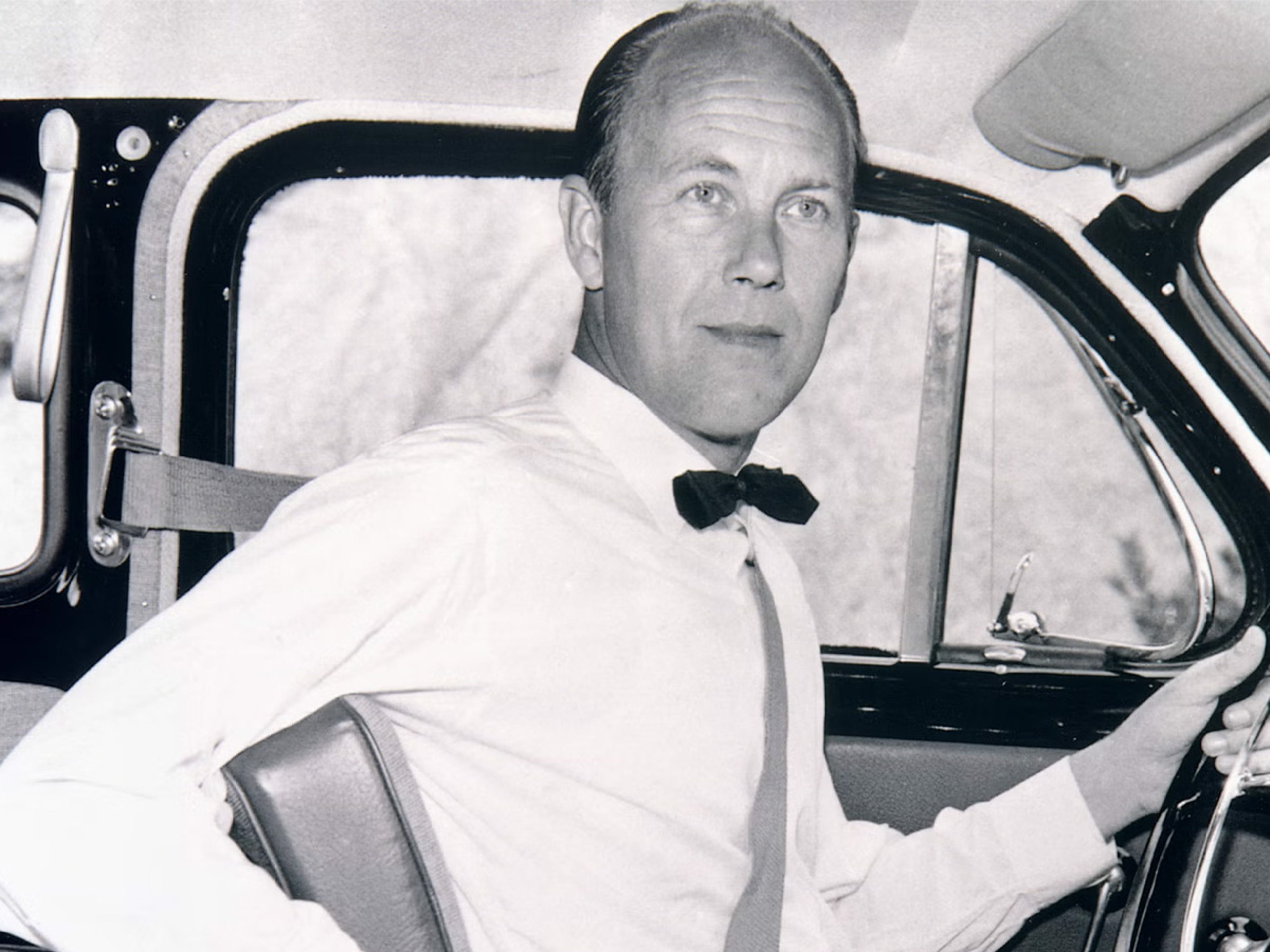 Volvo 3-point safety, man demonstrating safety belt in car