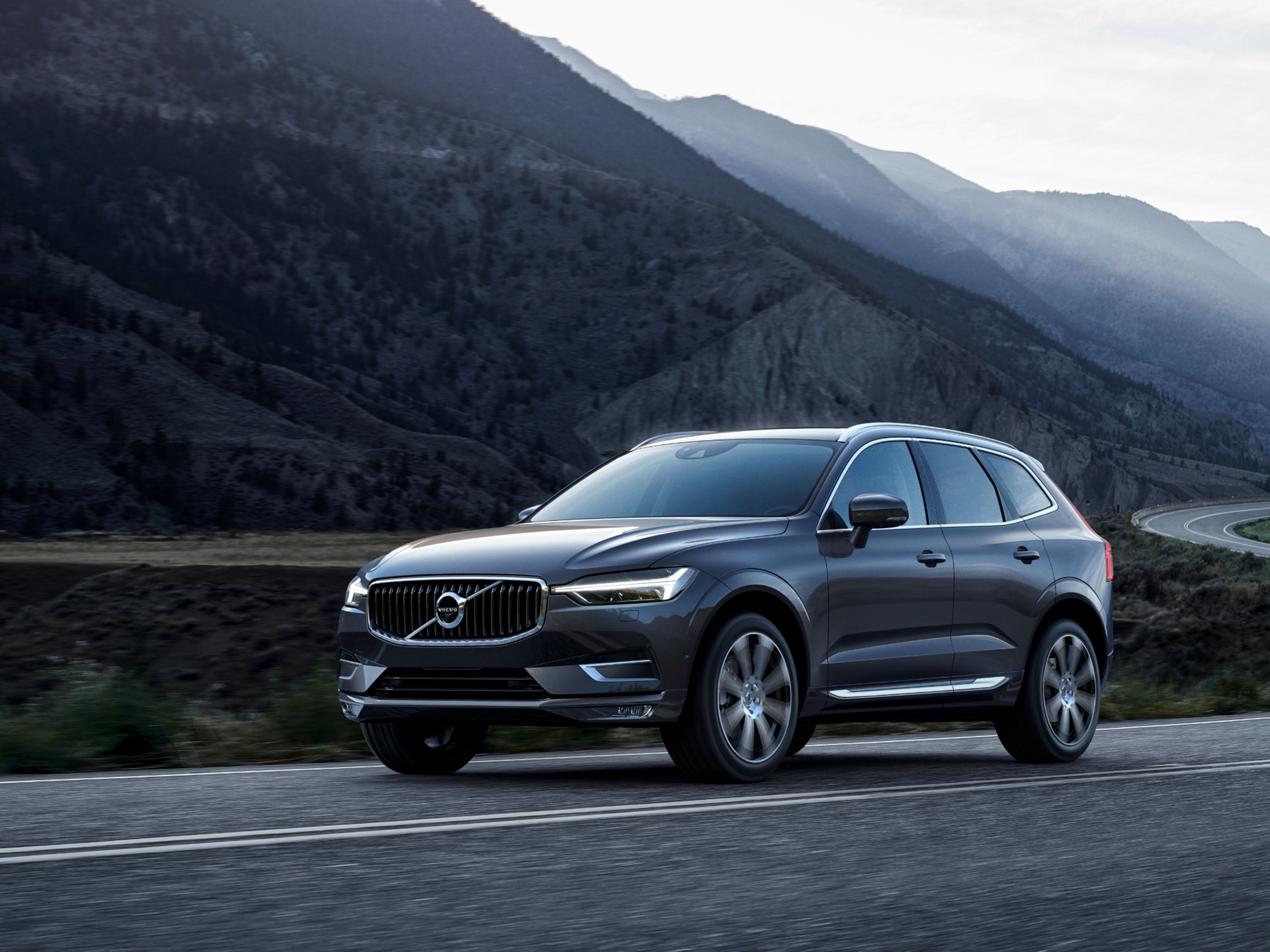 Un Volvo XC60 sobre una carretera con montañas de fondo.