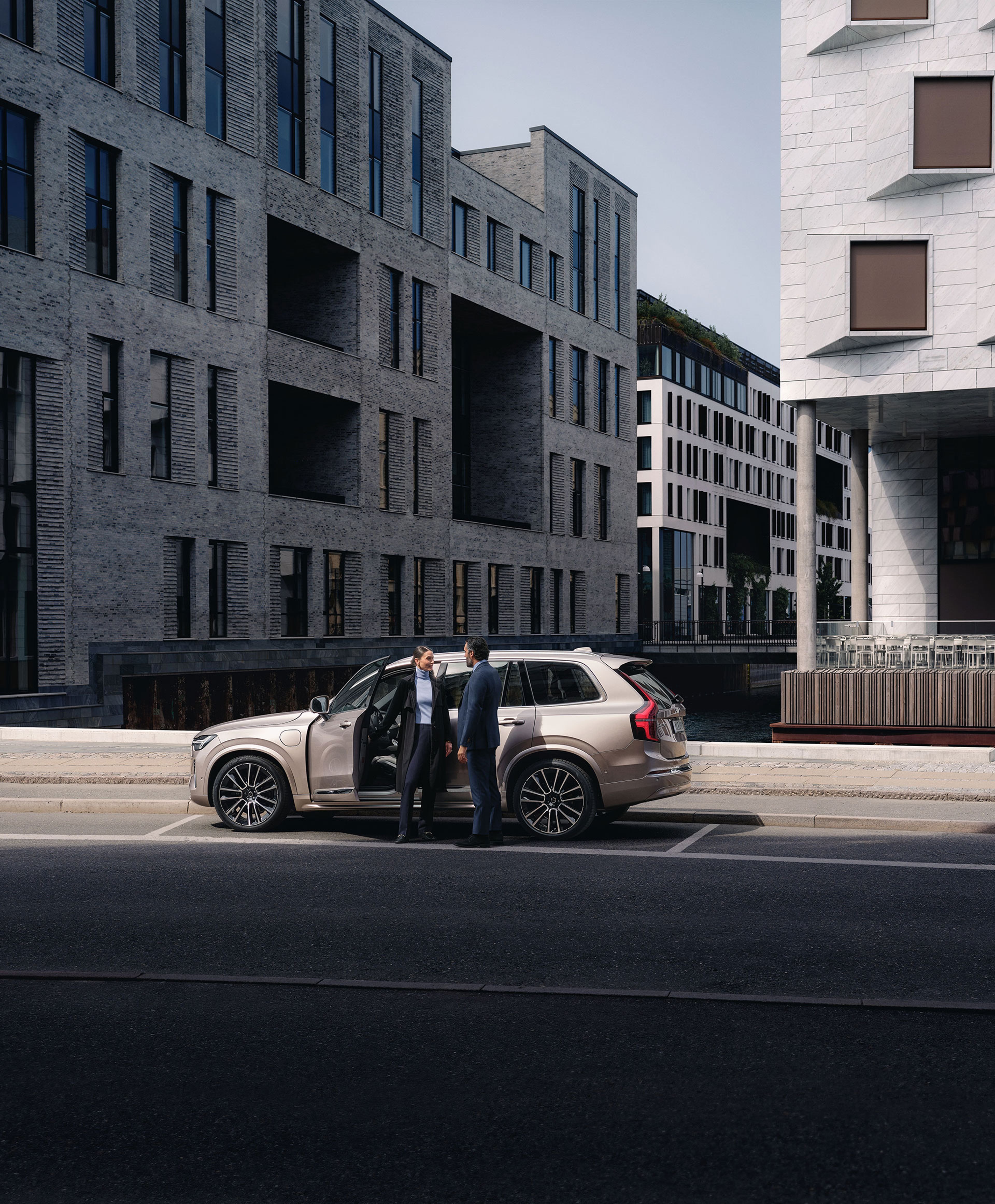 En mand og en kvinde står foran en XC90 forretningsbil