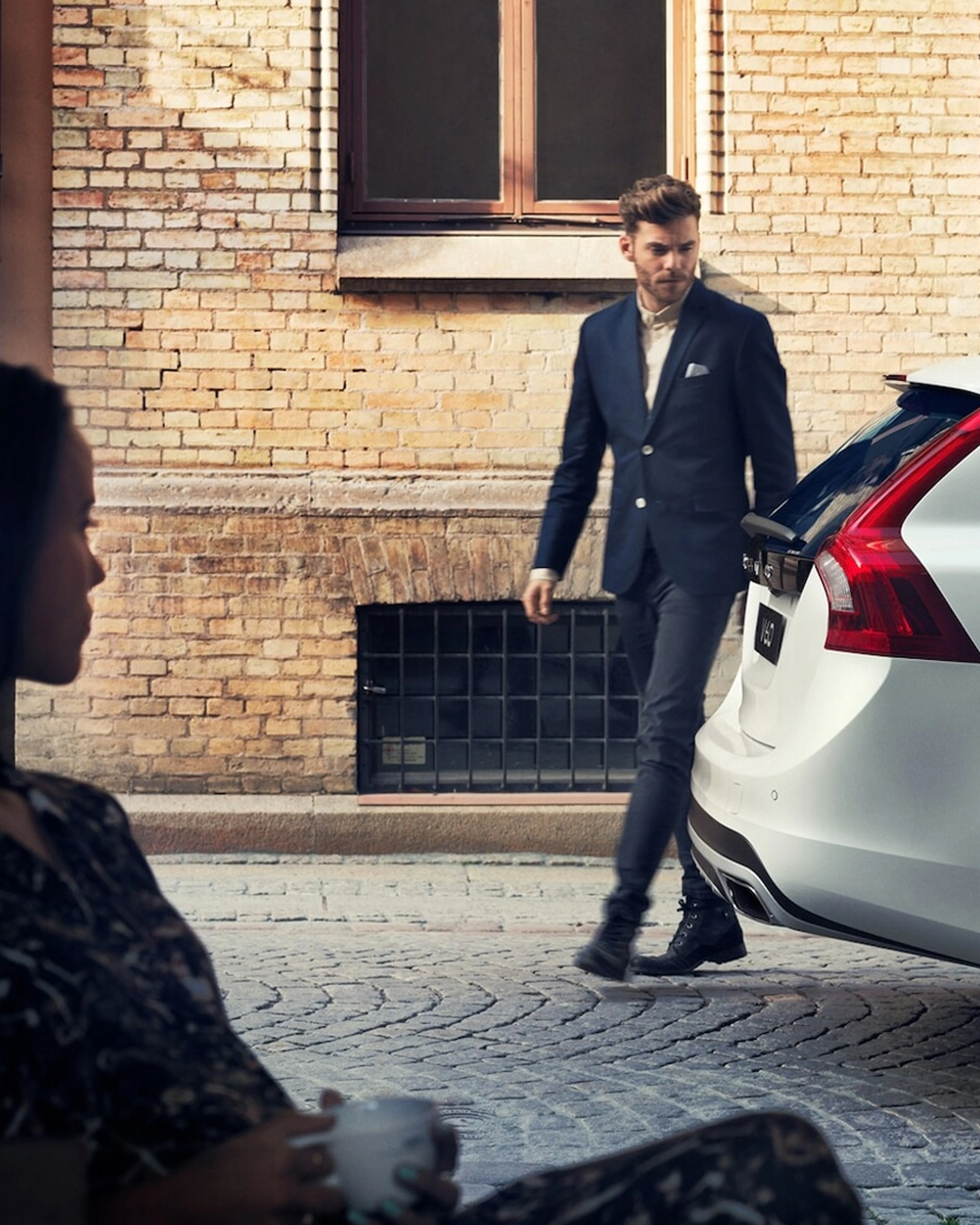 Mann i dress går bak en hvit V60